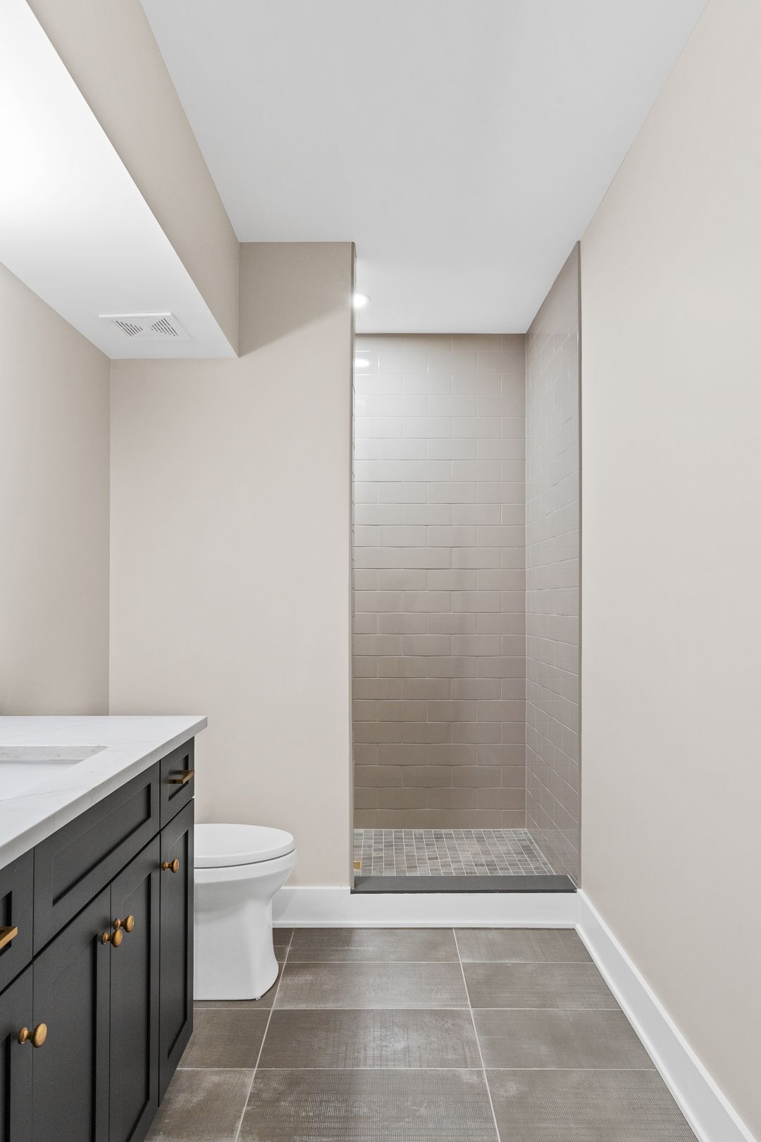 A bathroom with a toilet , sink , and walk in shower.