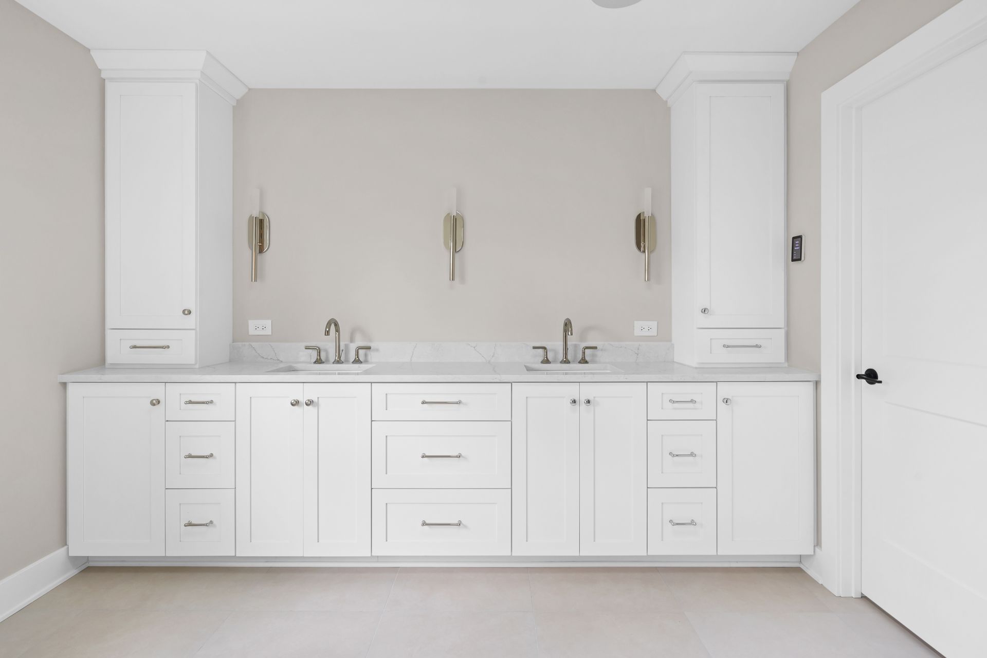 A bathroom with two sinks and white cabinets.