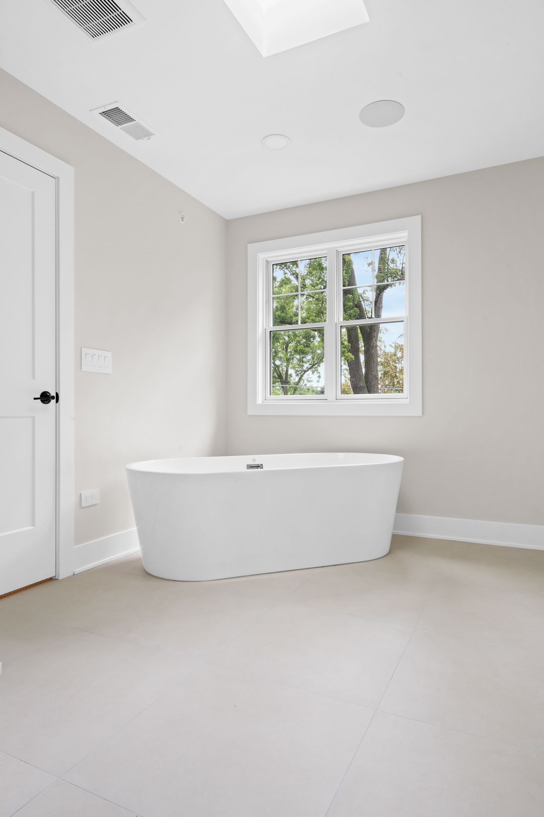 A bathroom with a freestanding tub and a window.