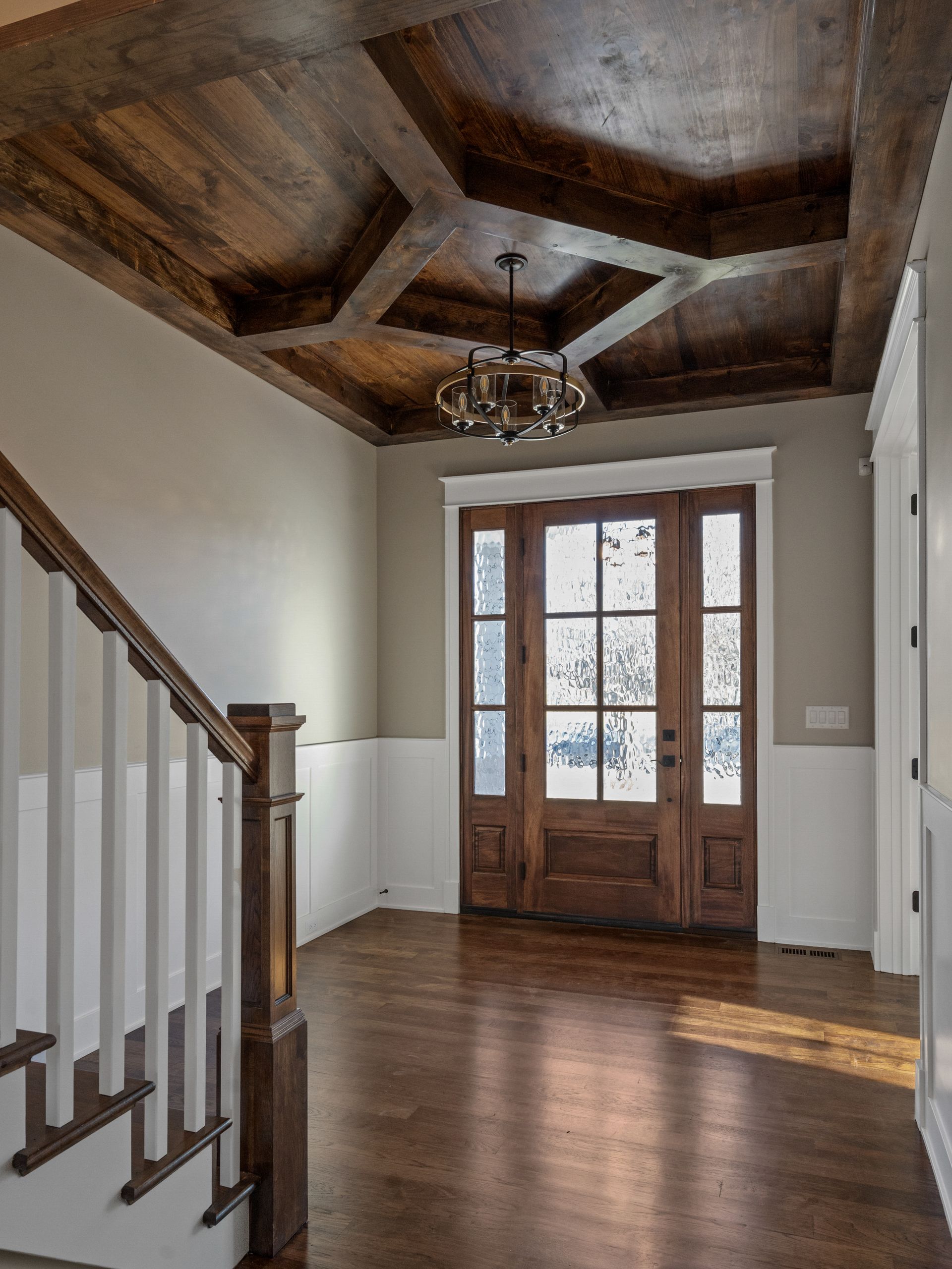 An empty hallway with a wooden ceiling and stairs
