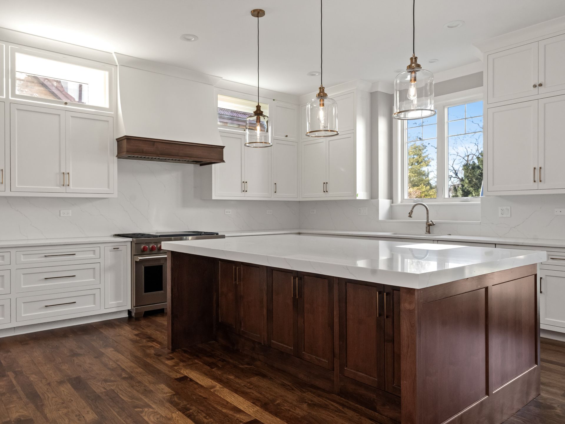 A kitchen with white cabinets and a large island in the middle.