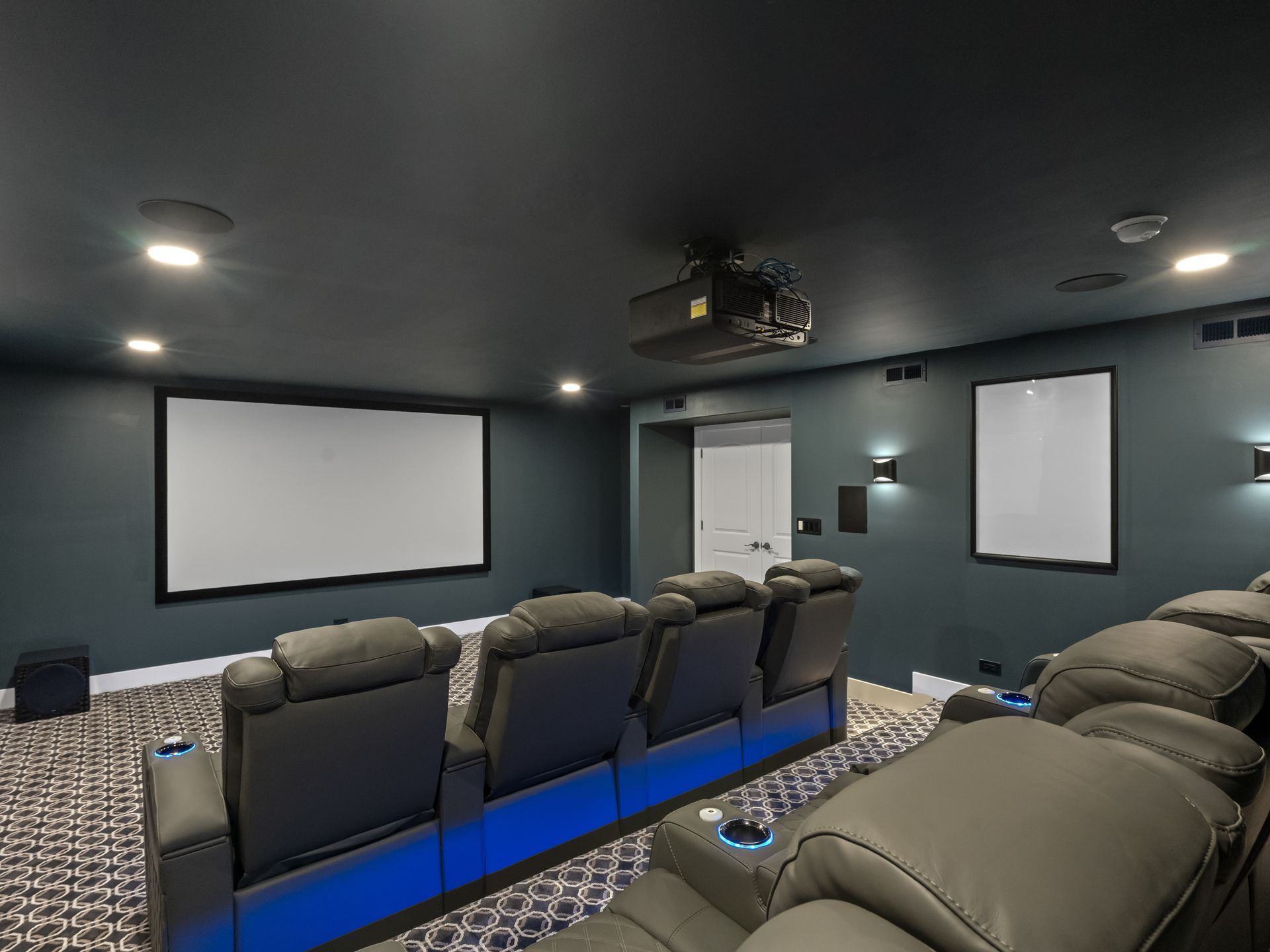A home theater with a projector and a large screen.