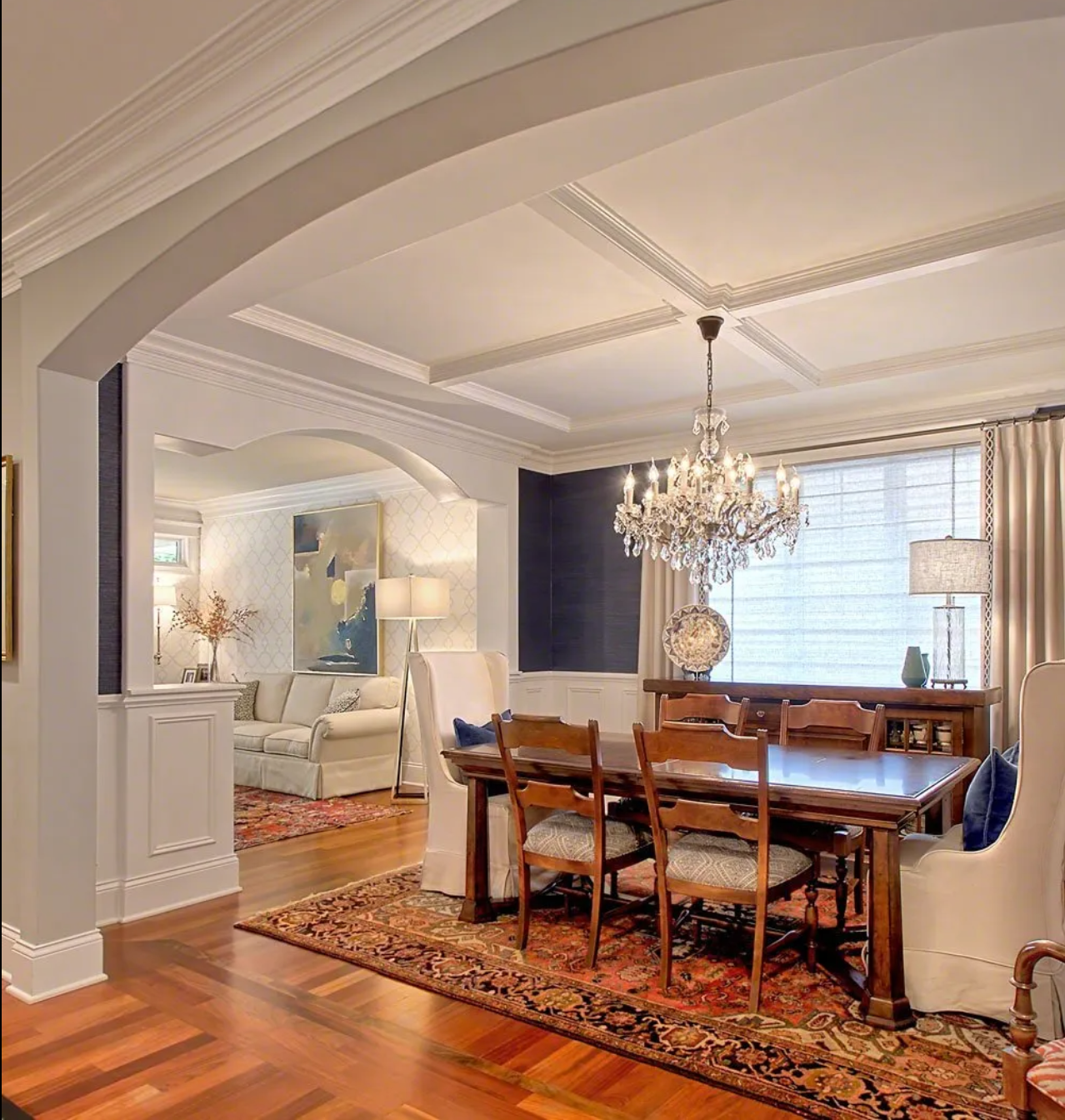 A dining room with a table and chairs and a chandelier