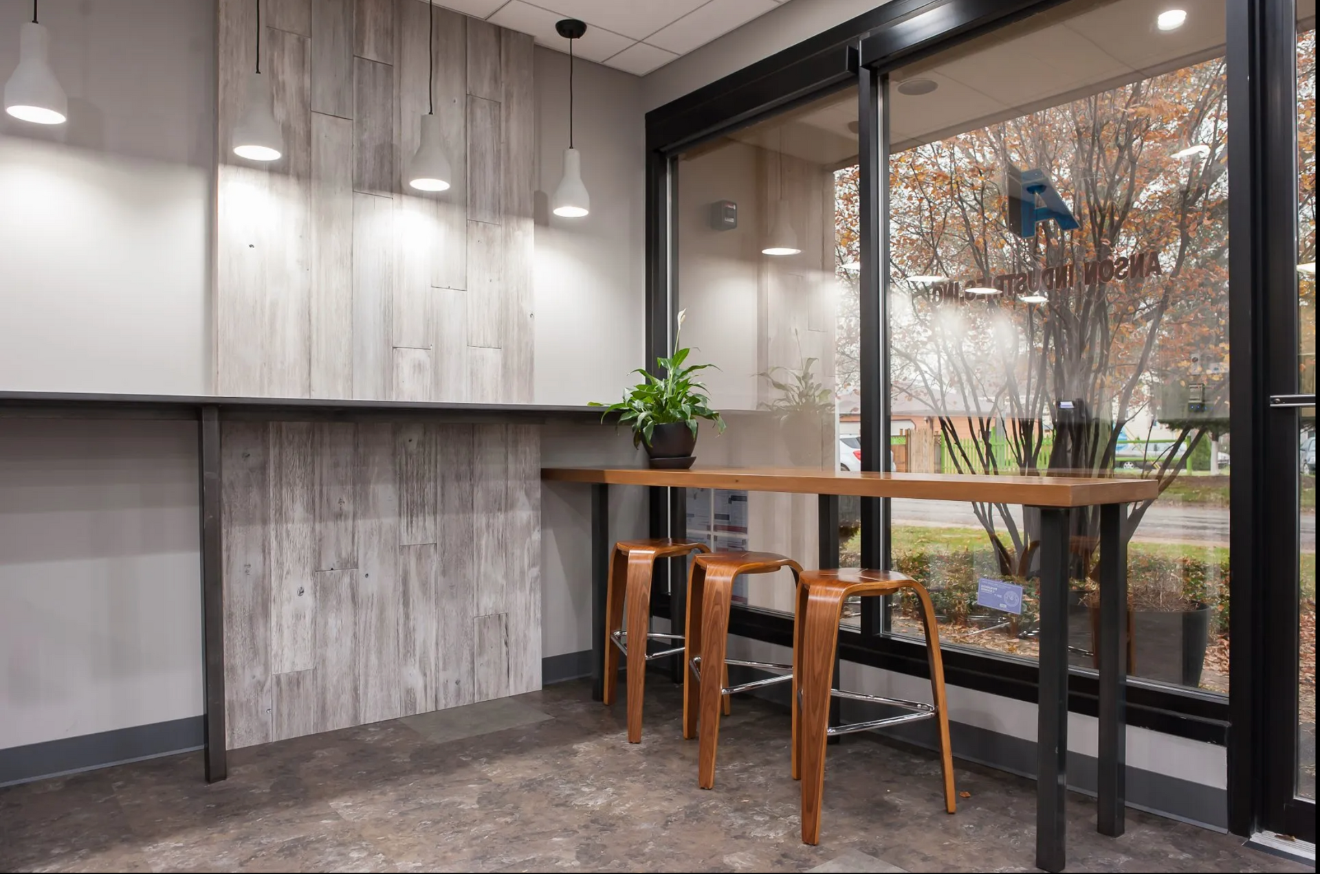 A room with a table and stools in front of a window.
