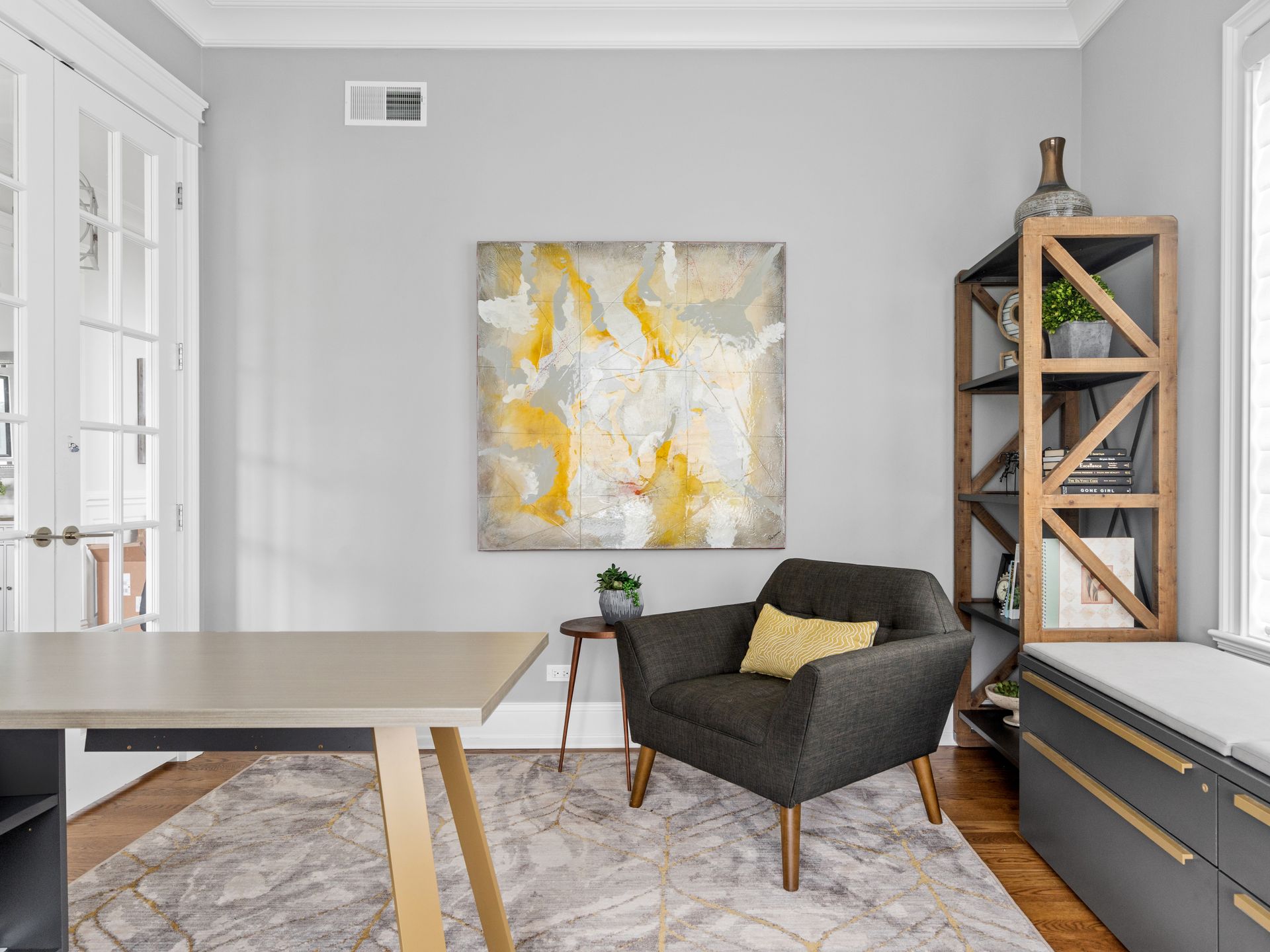 There is a painting on the wall above the chair in the room.