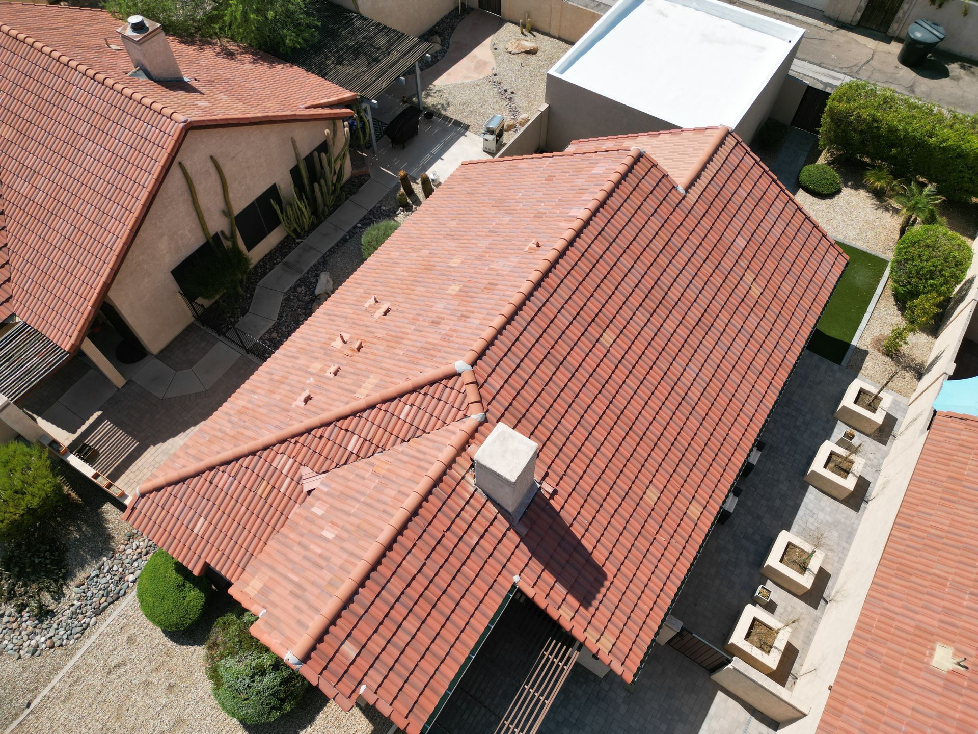 White stucco flat roof area next to a red tile roof.