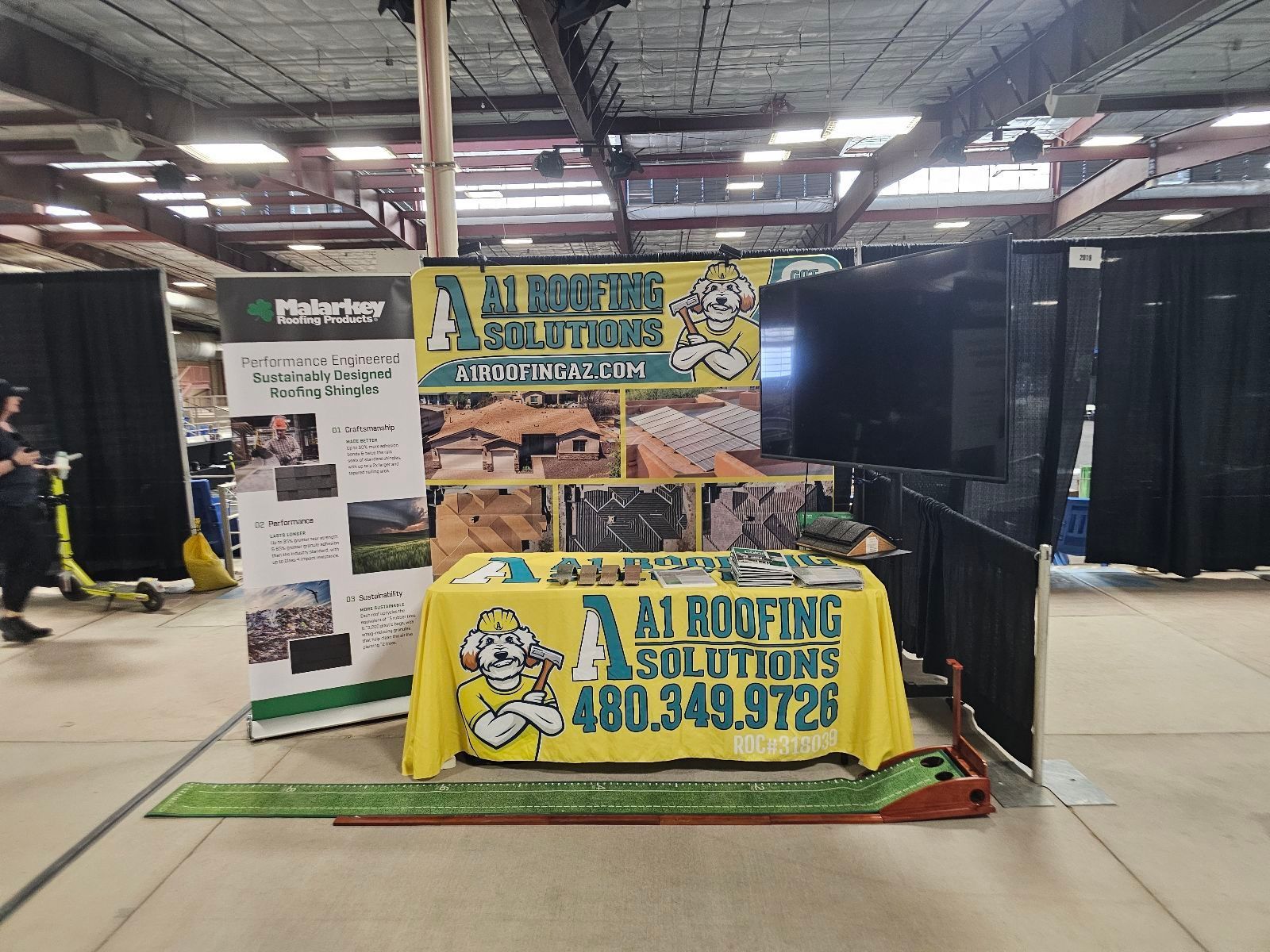 A trade show booth with a yellow table and banner that says 