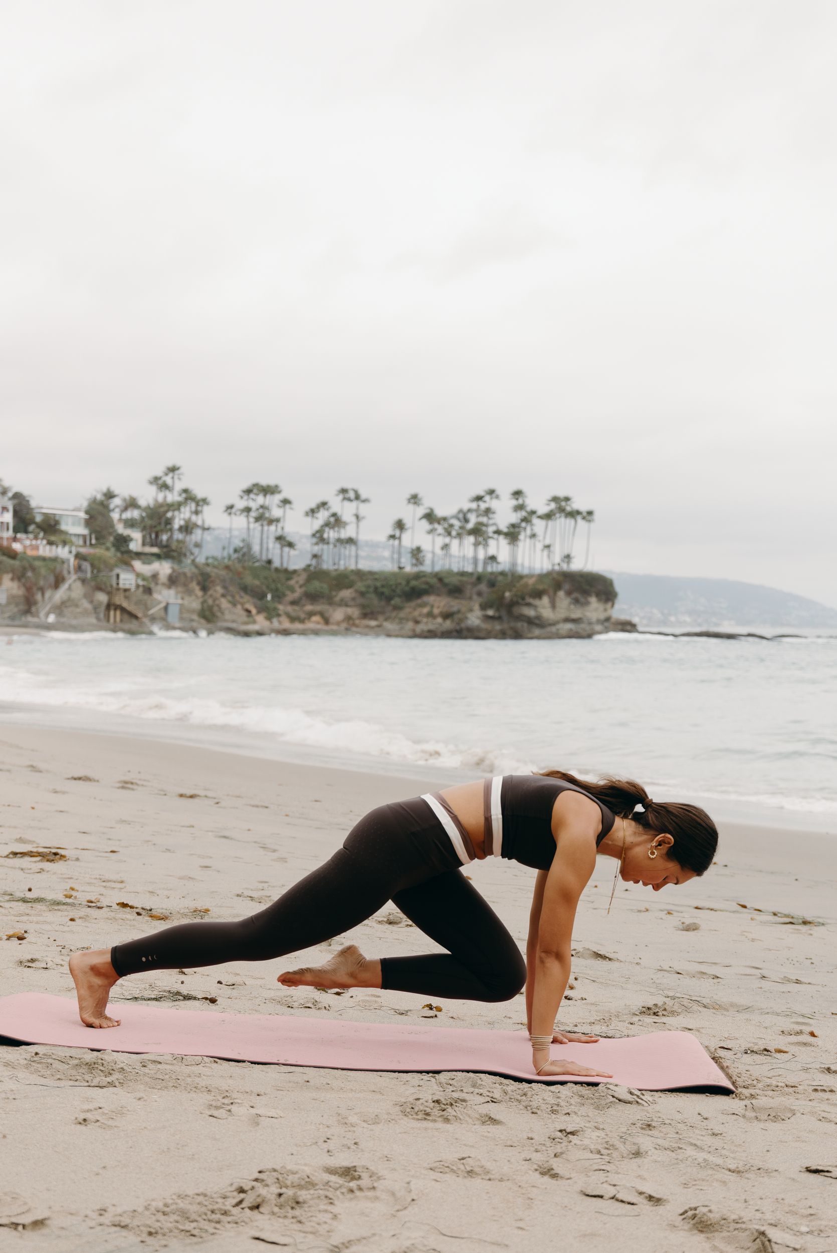 Une femme est assise en position du lotus devant une piscine.