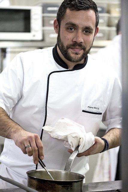 Un homme en uniforme de chef cuisine dans une marmite.