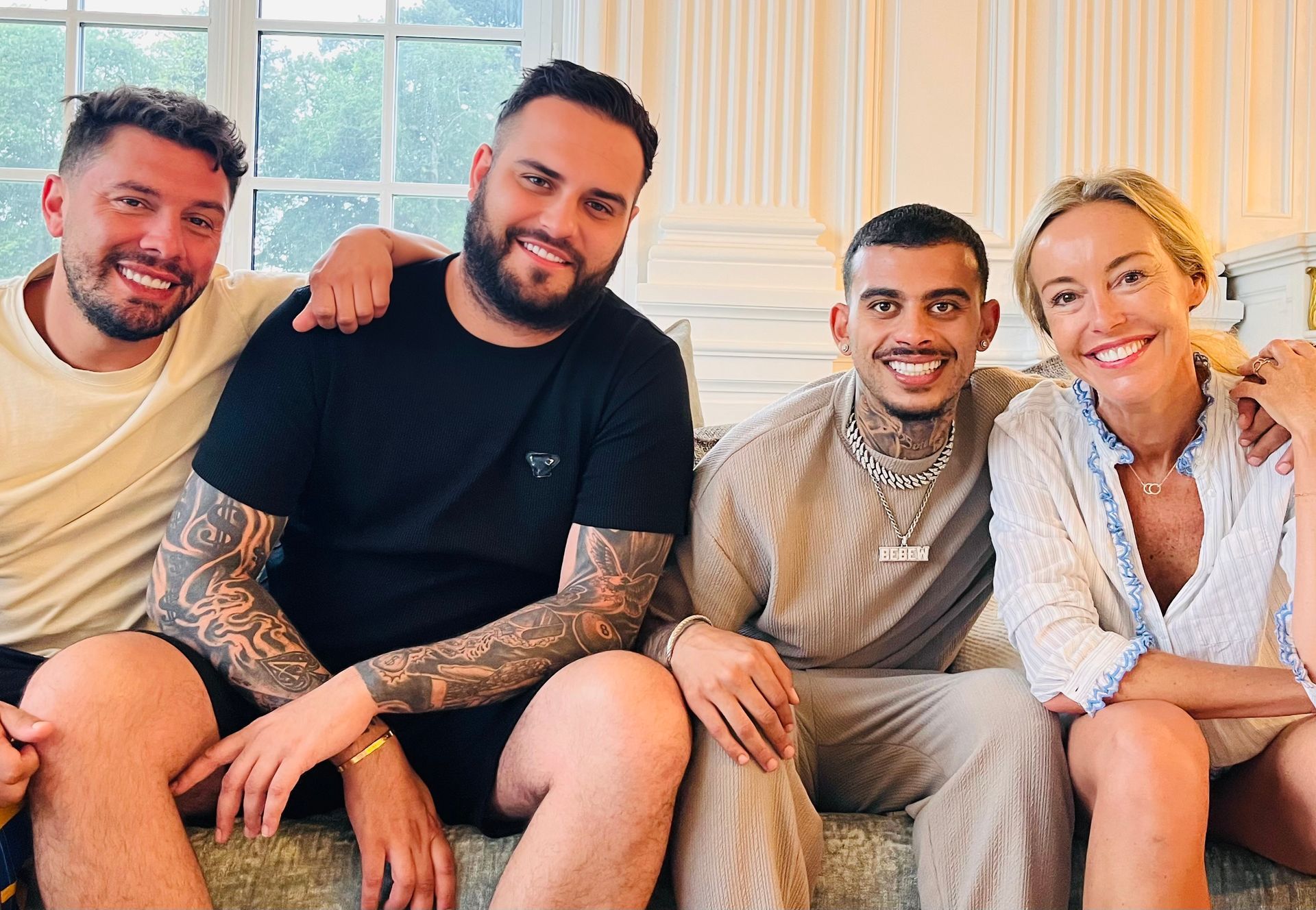 Un groupe de personnes sont assises sur un canapé et posent pour une photo.