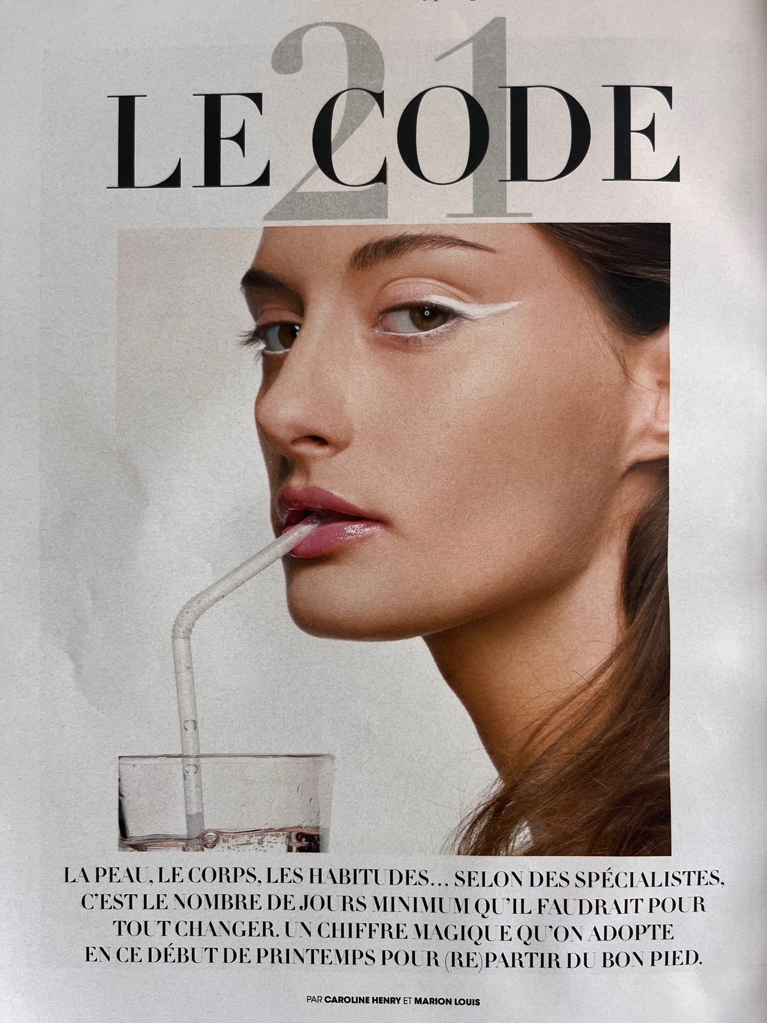 Une couverture de magazine avec une femme buvant de l'eau avec une paille