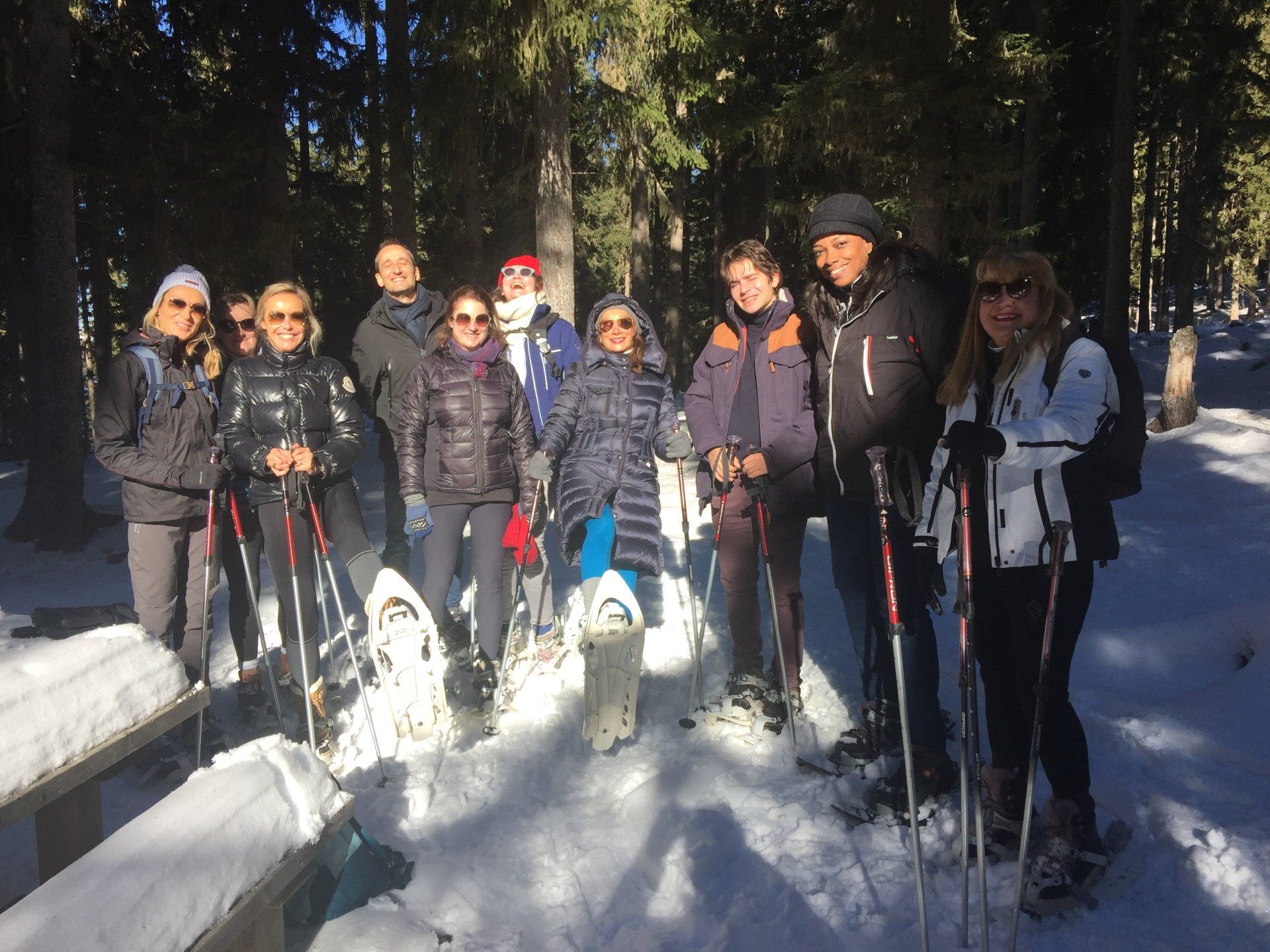 Un groupe de personnes se tient debout dans la neige avec des raquettes.