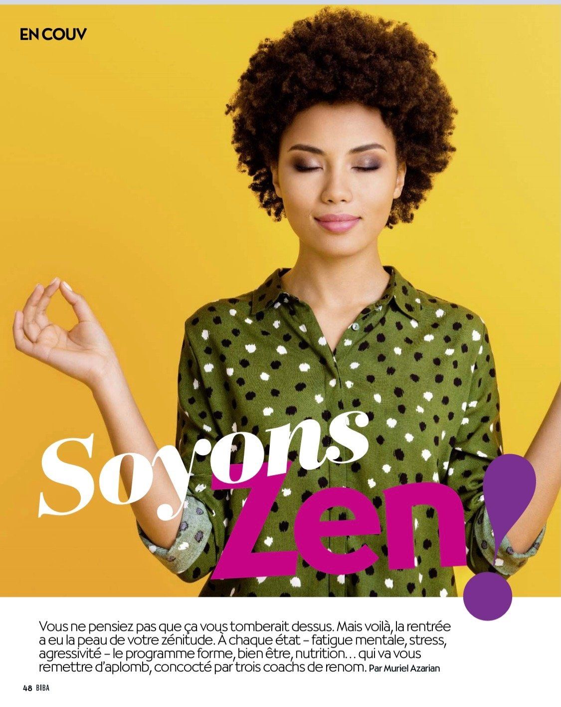 Une femme en chemise à pois verts médite les yeux fermés.