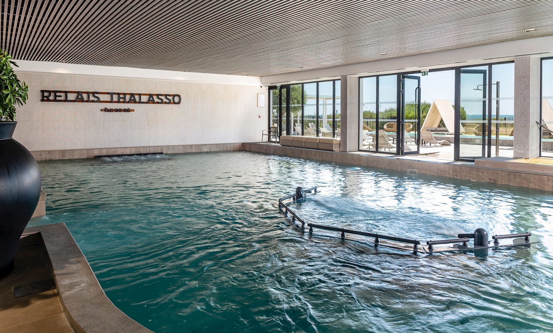 Une grande piscine intérieure avec beaucoup de chaises autour.
