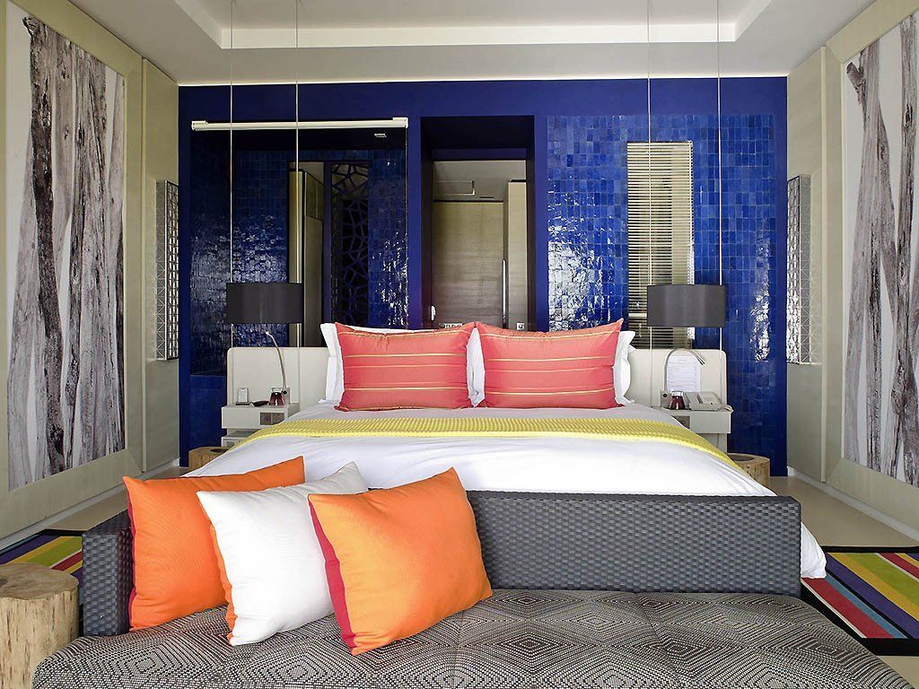 Une chambre avec un grand lit et des oreillers colorés