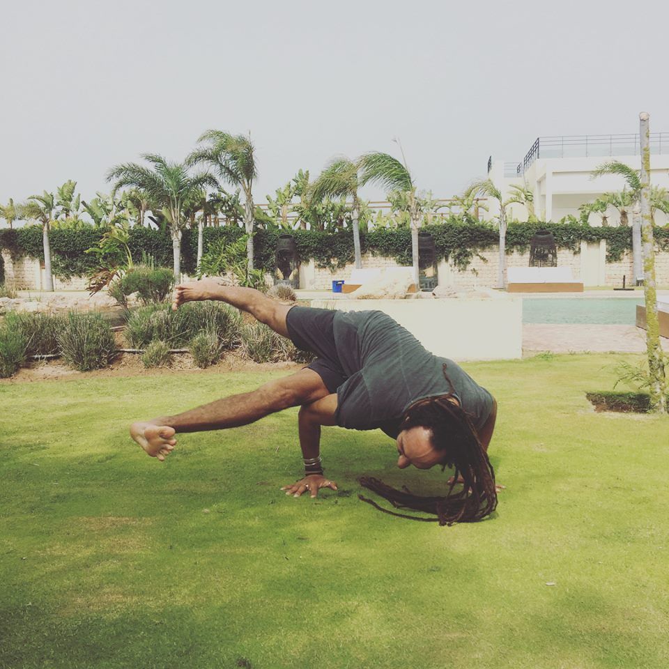 Un homme fait le poirier dans l'herbe