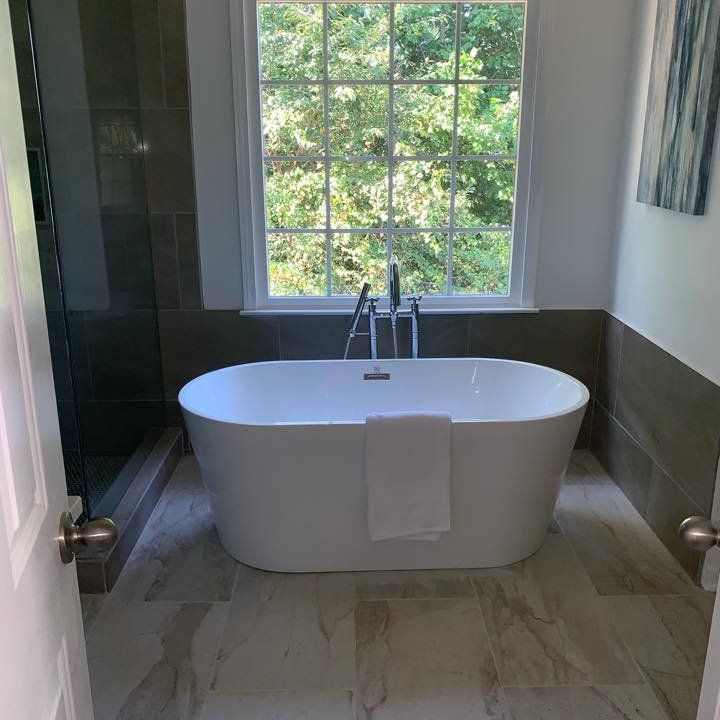 A bathtub is sitting in a bathroom next to a window.