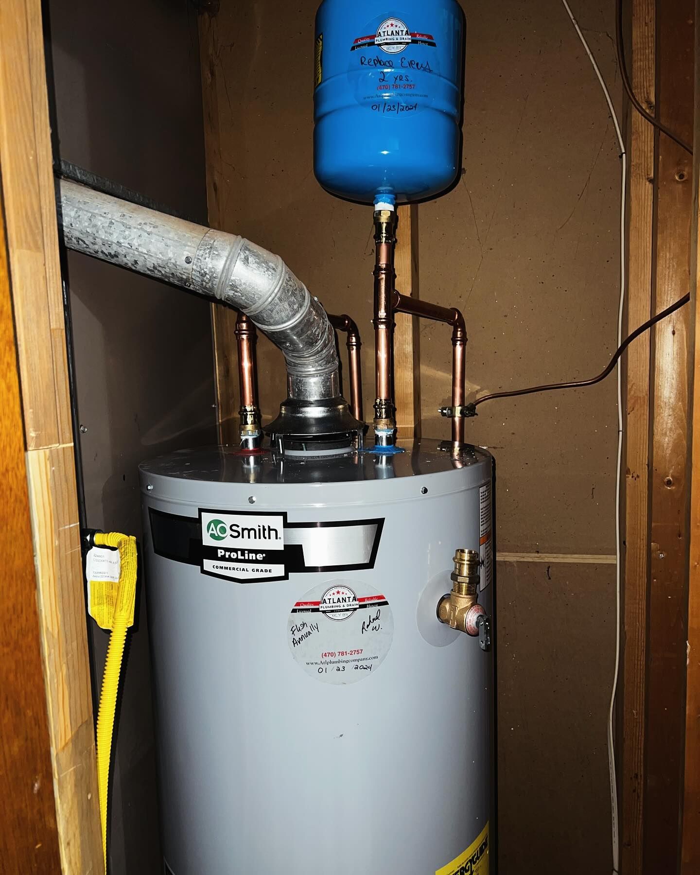 A smith water heater is sitting in a corner of a room.