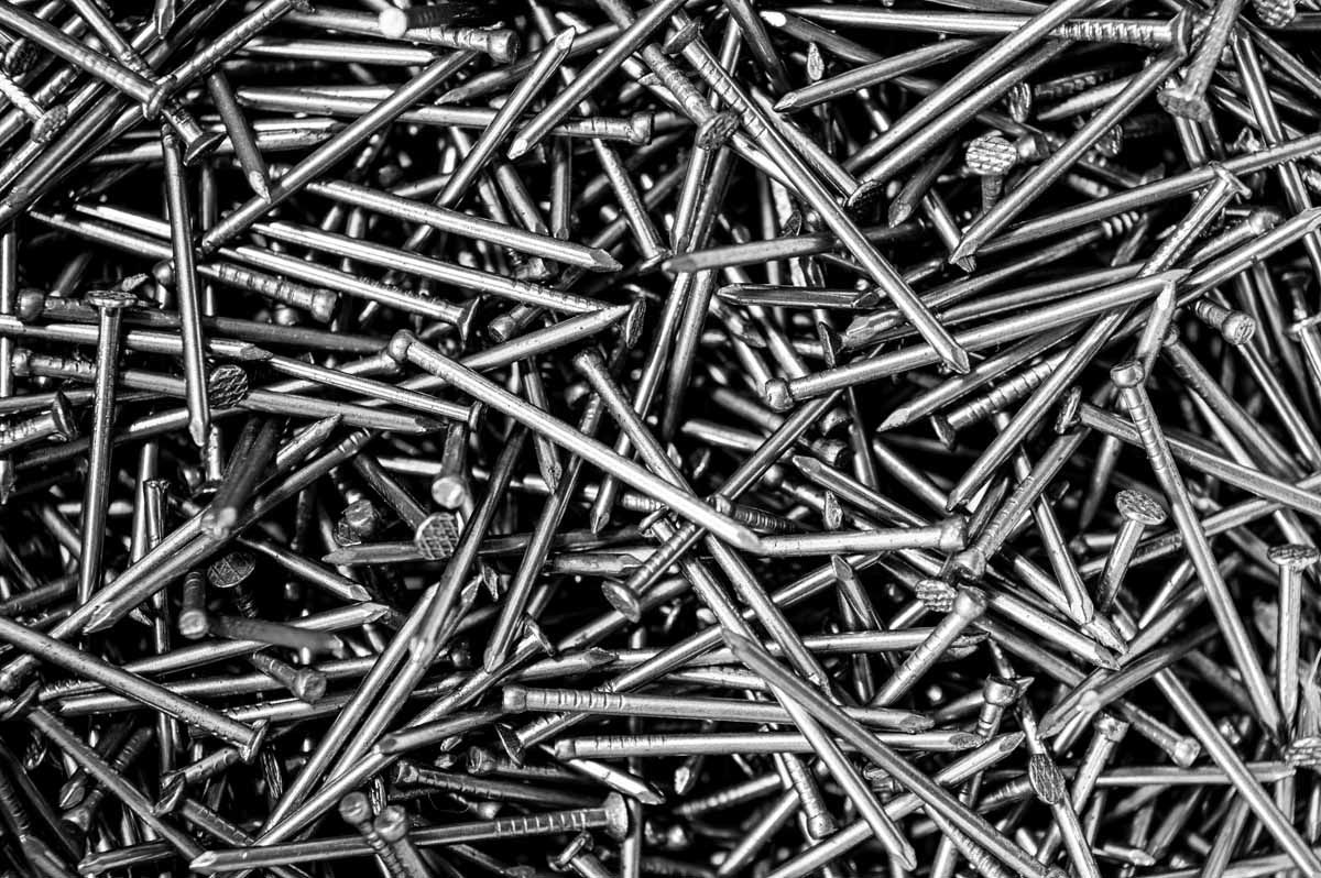Pile of silver nails, densely packed and overlapping.