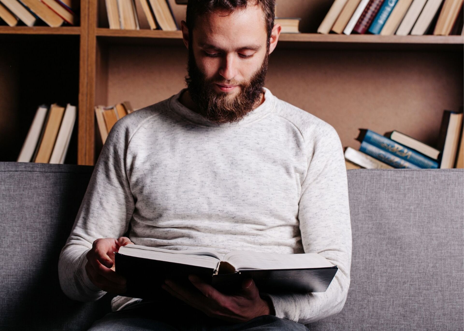 man practicing self care by reading a book