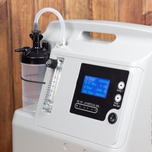 A white oxygen concentrator with a hose attached to it