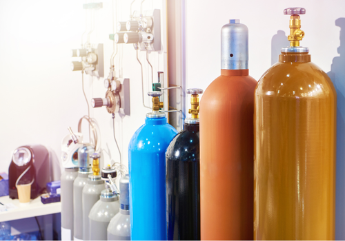 Various gas cylinders connected to a filling station in a facility.