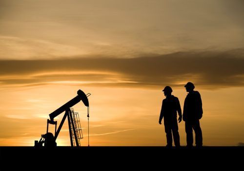 A person wearing blue gloves is working on a conveyor belt in a factory.