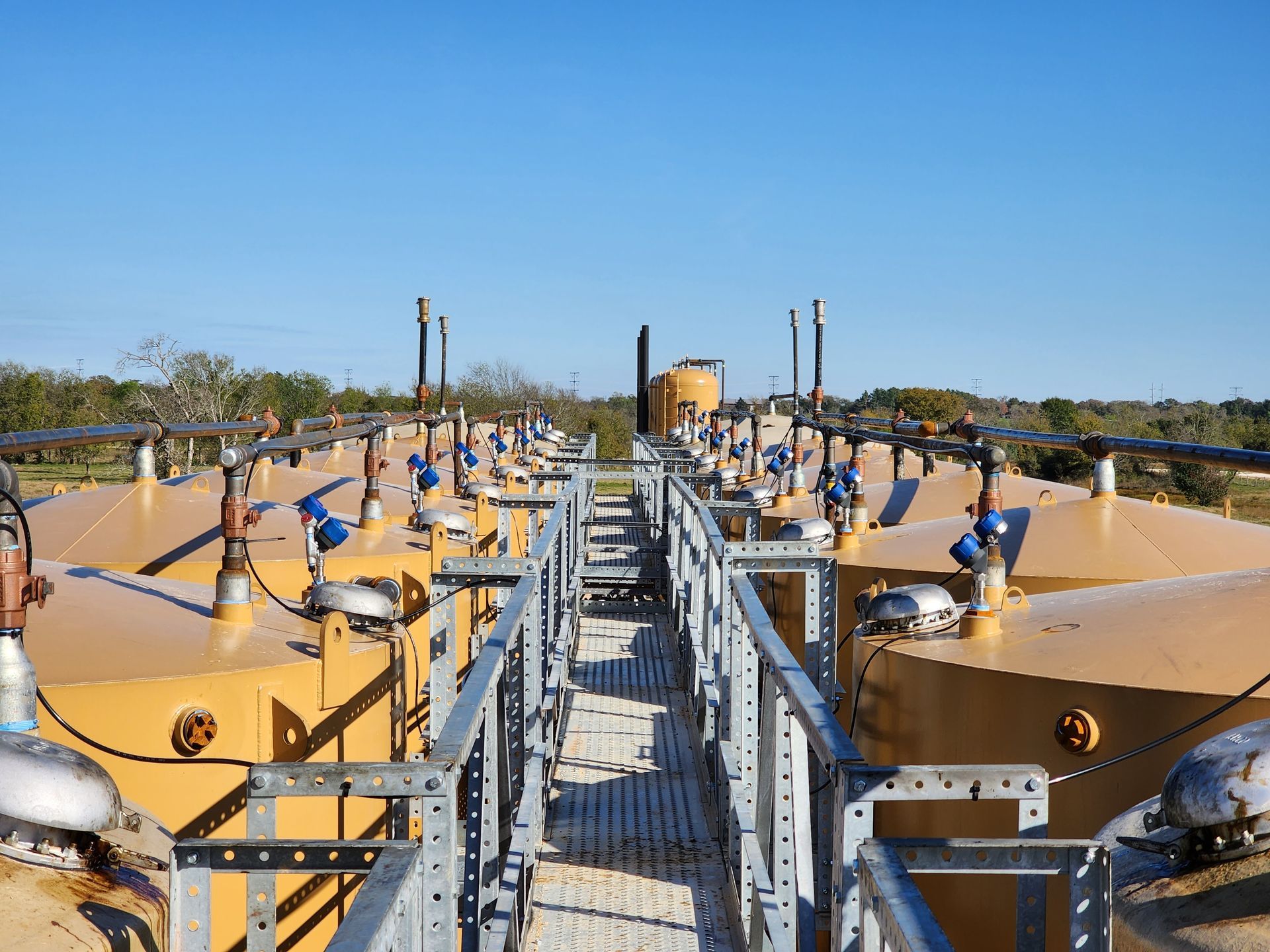 Yellow Tanks are on top of a Metal Platform - Dime Box, TX - Diamond P. Lease & Well Service Inc.