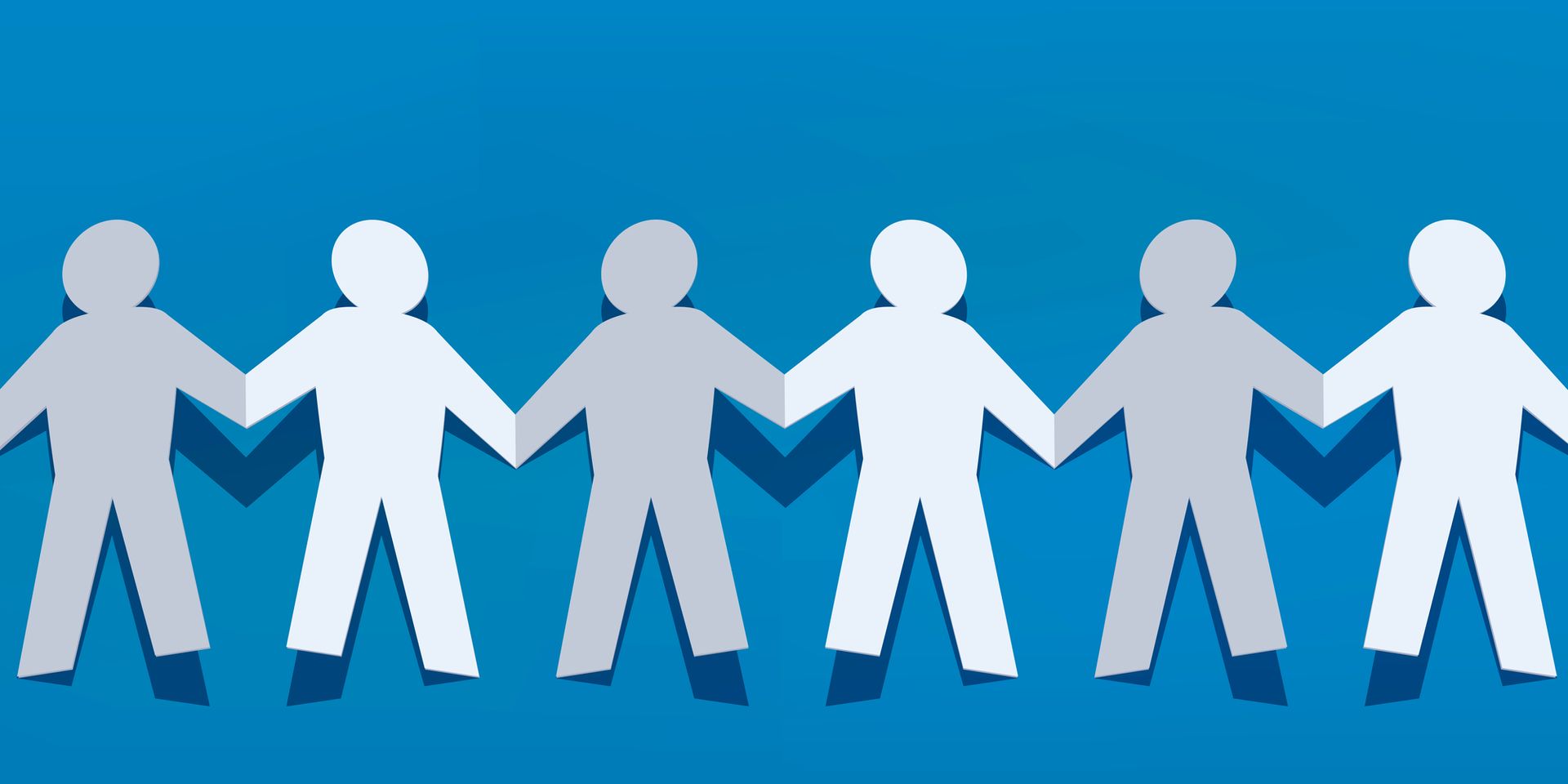 A row of paper people holding hands on a blue background
