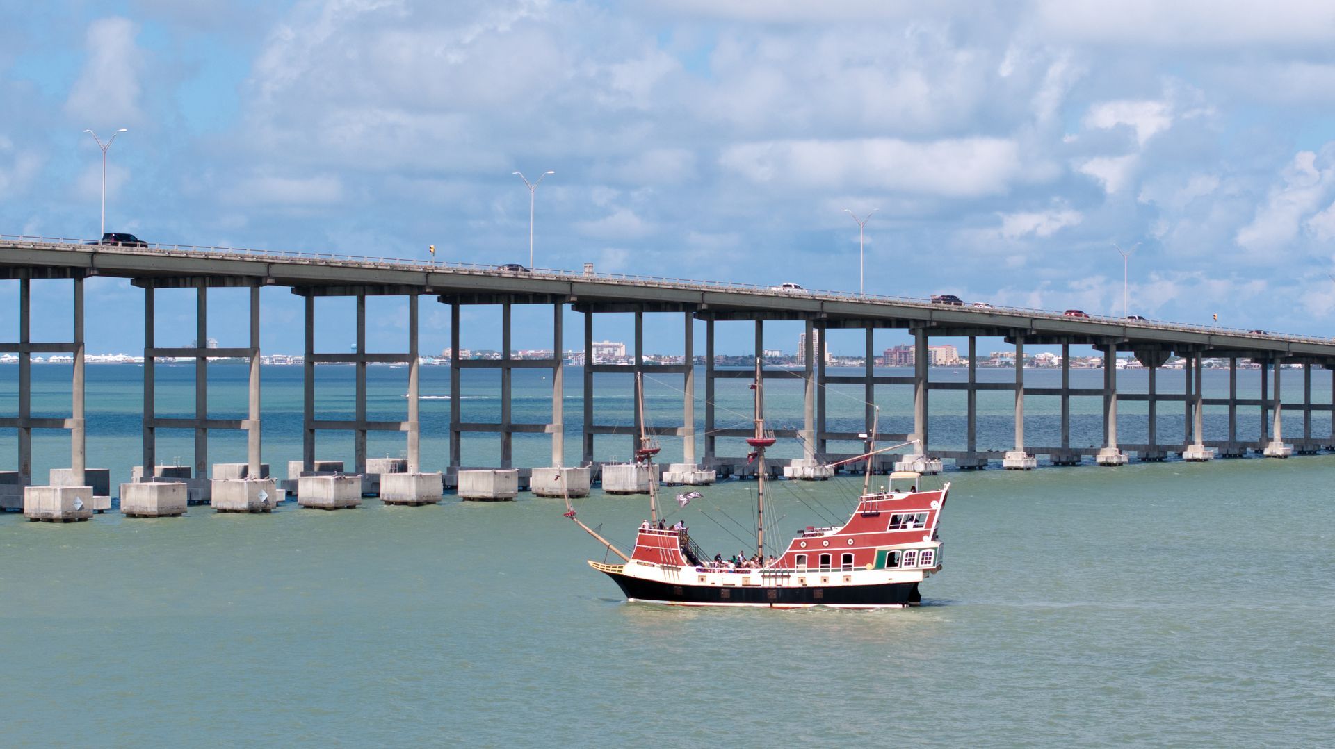 A bridge over a body of water with a boat in the foreground