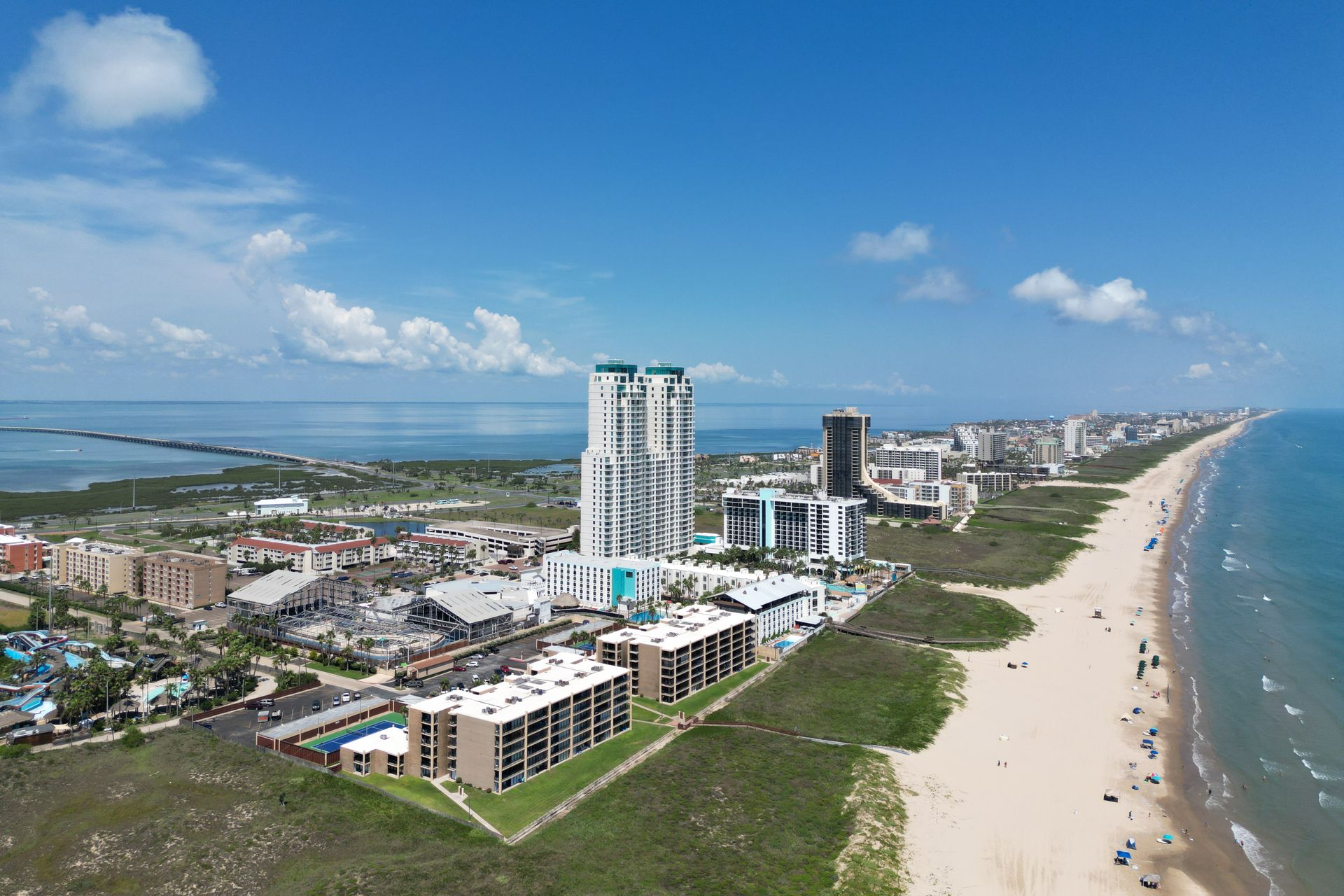 An aerial view of a beach with a city in the background.