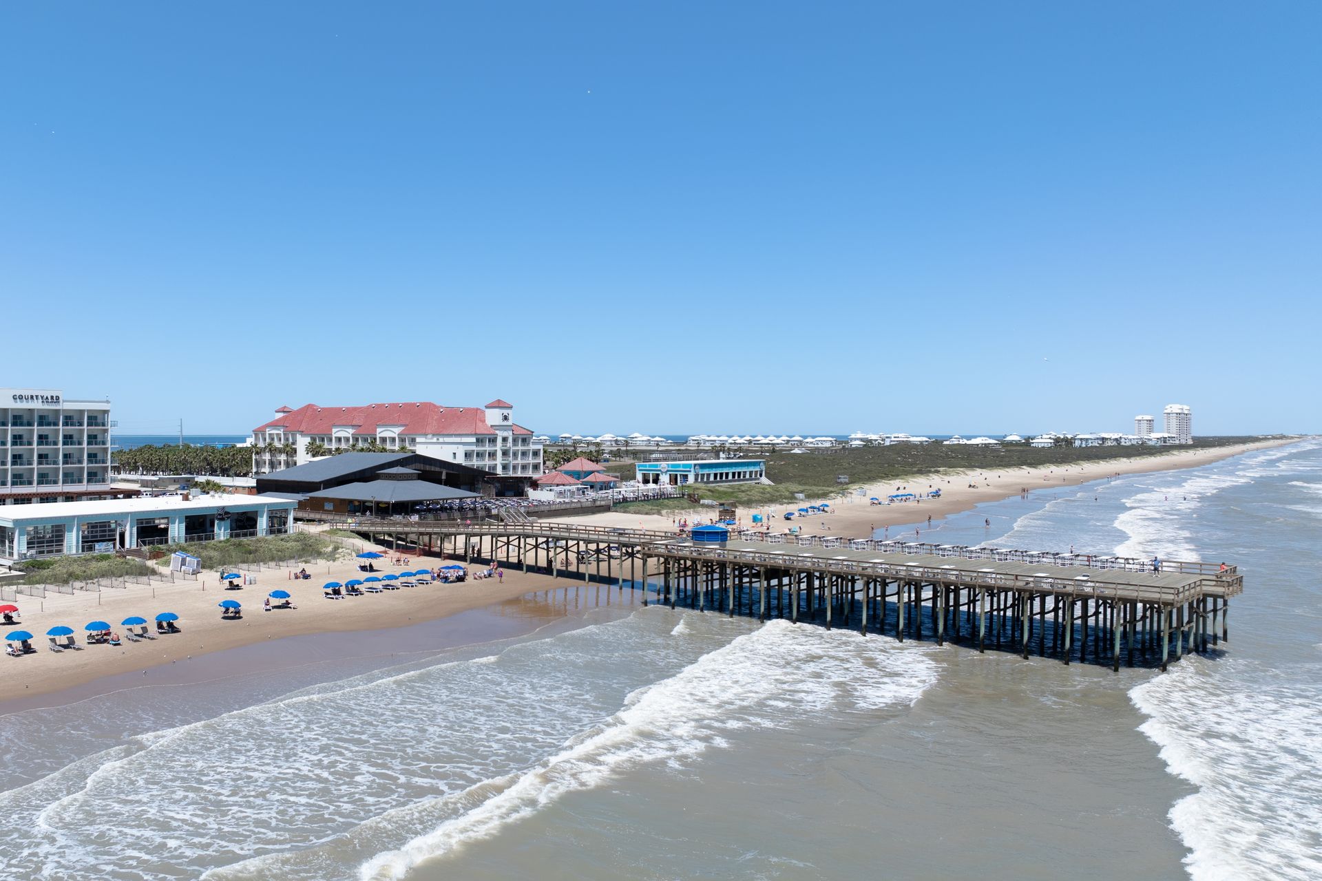An aerial view of a pier leading into the ocean.