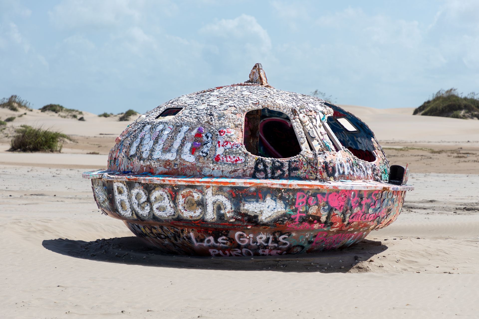 A sculpture on a beach with the word beach written on it.