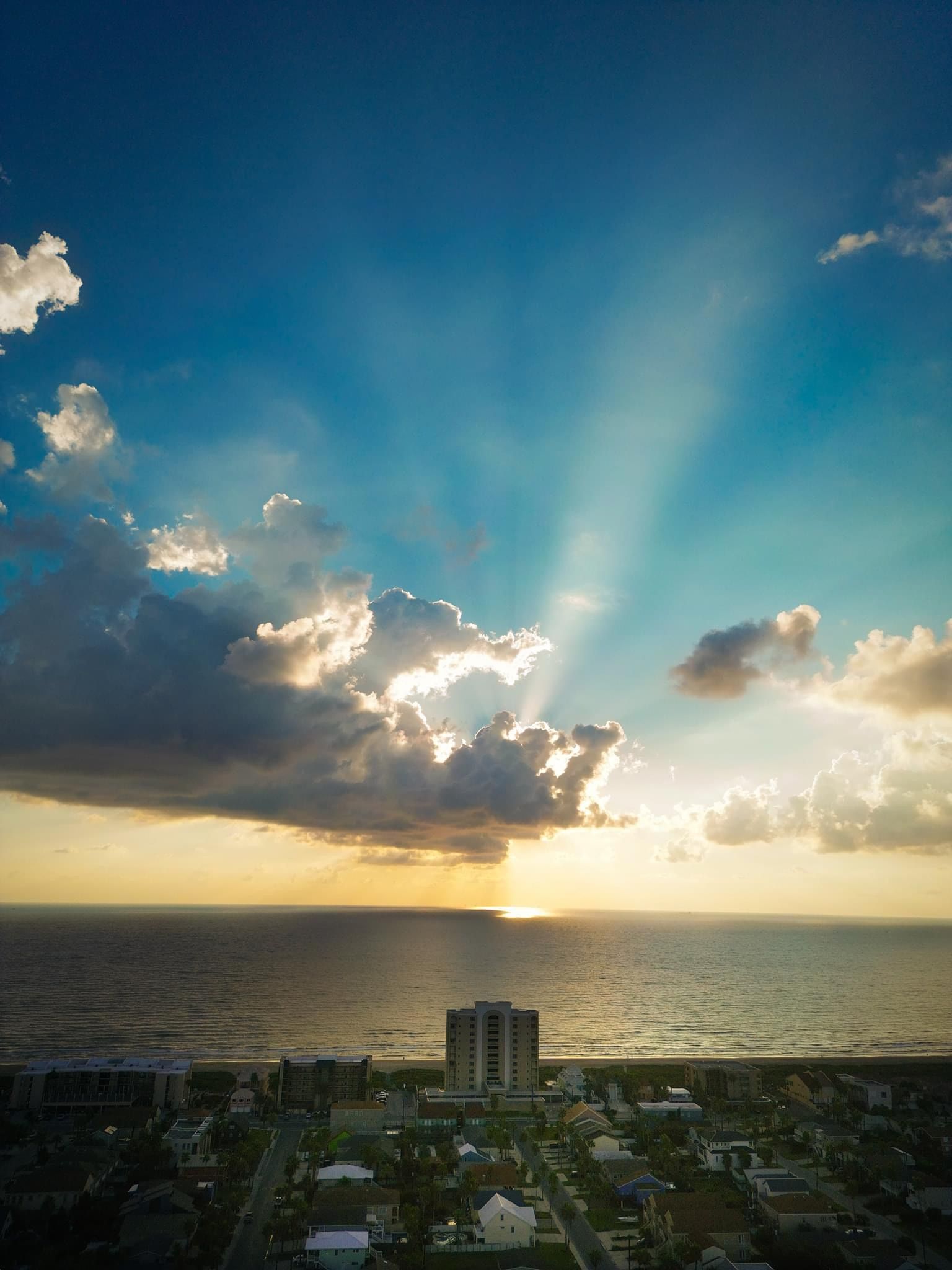 The sun is shining through the clouds over the ocean