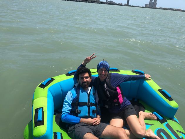 A man and a woman are sitting on an inflatable boat in the water.