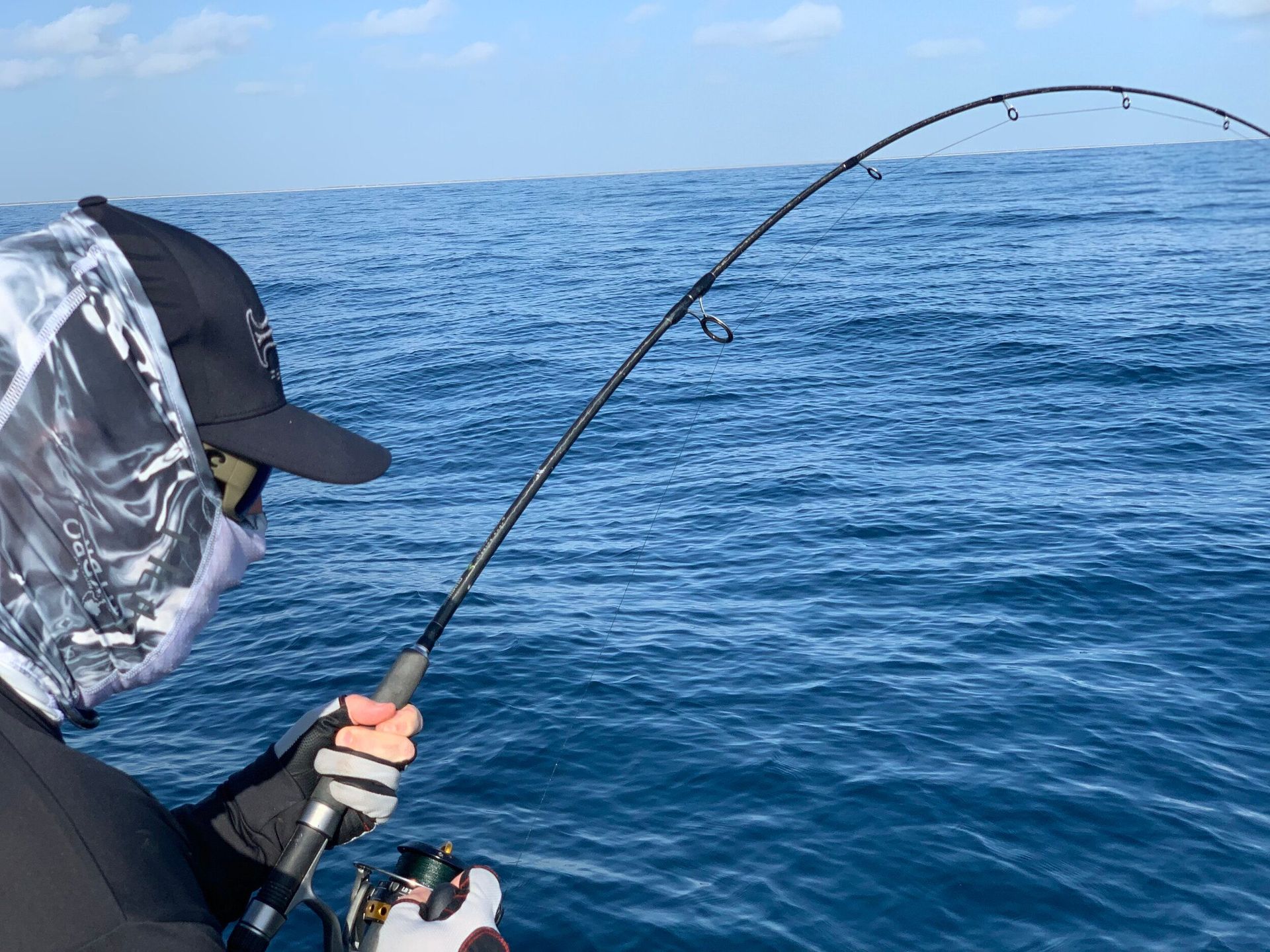 A man is fishing in the ocean with a fishing rod.