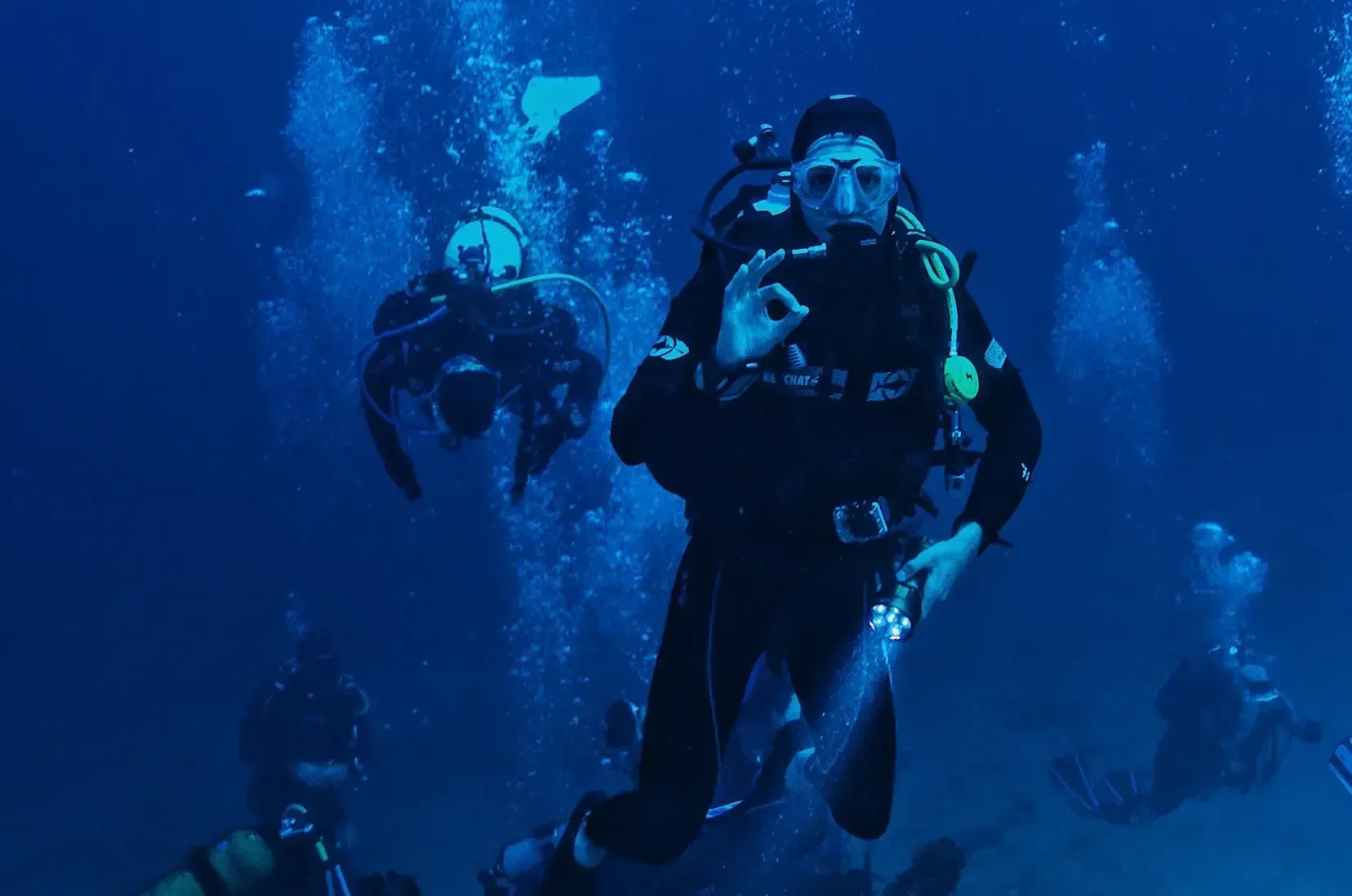 A group of scuba divers are swimming in the ocean.