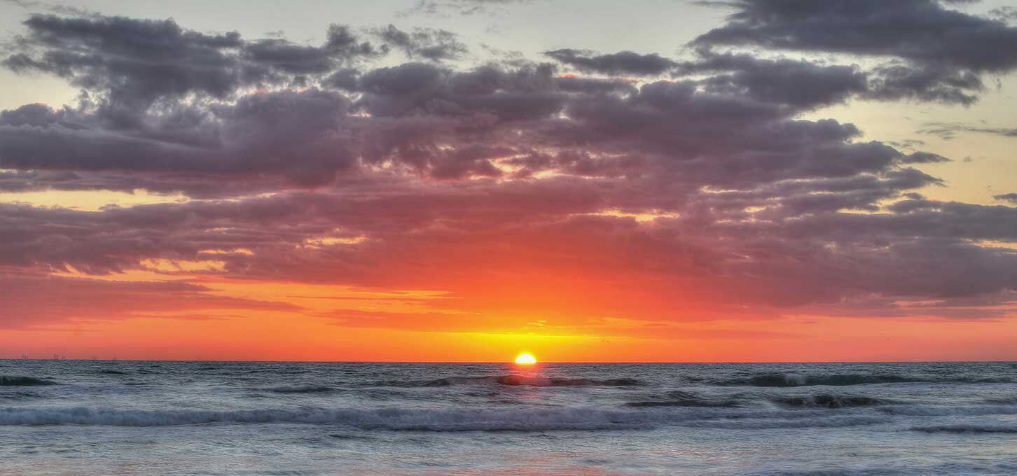 The sun is setting over the ocean.