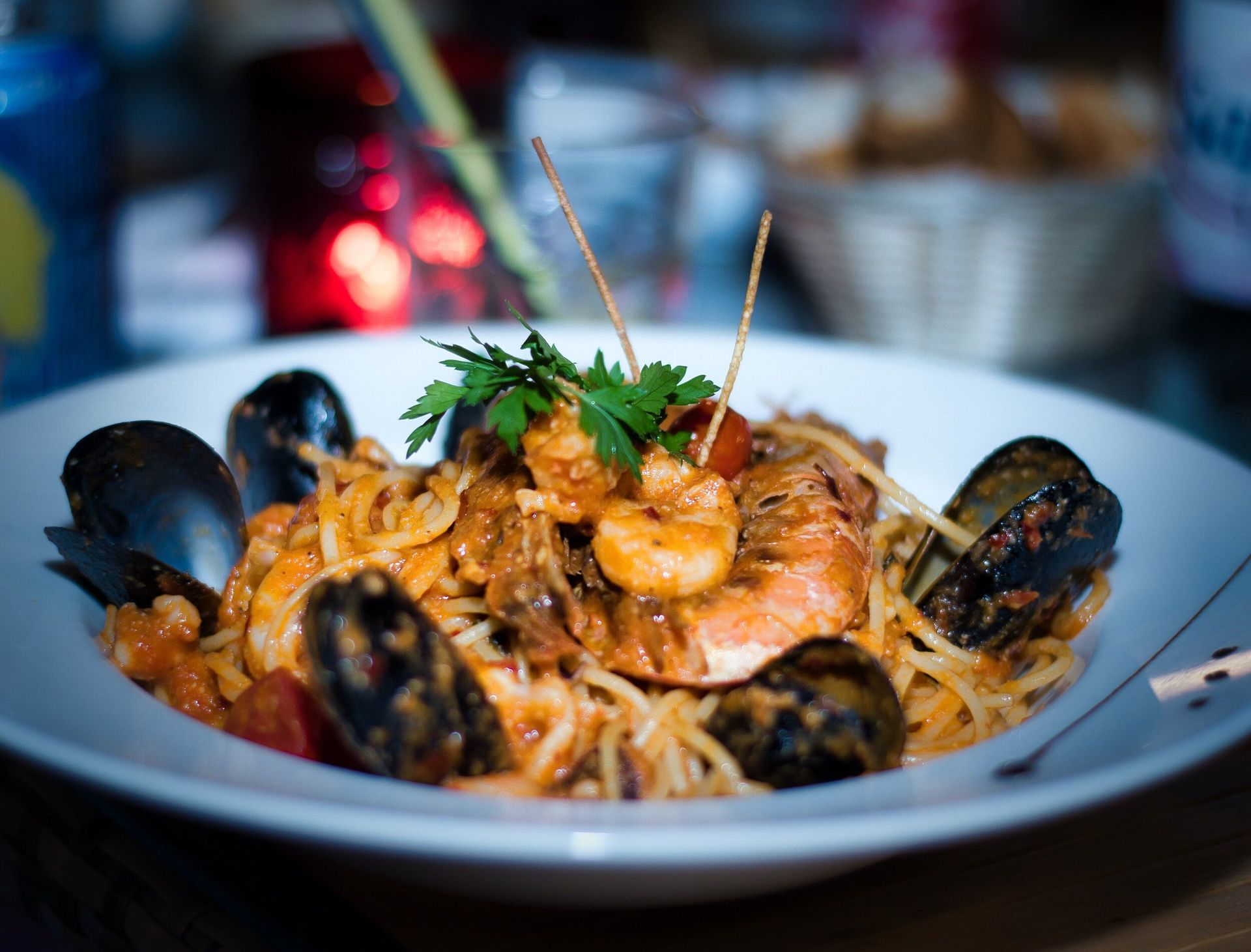 A plate of spaghetti with shrimp and mussels on a table.