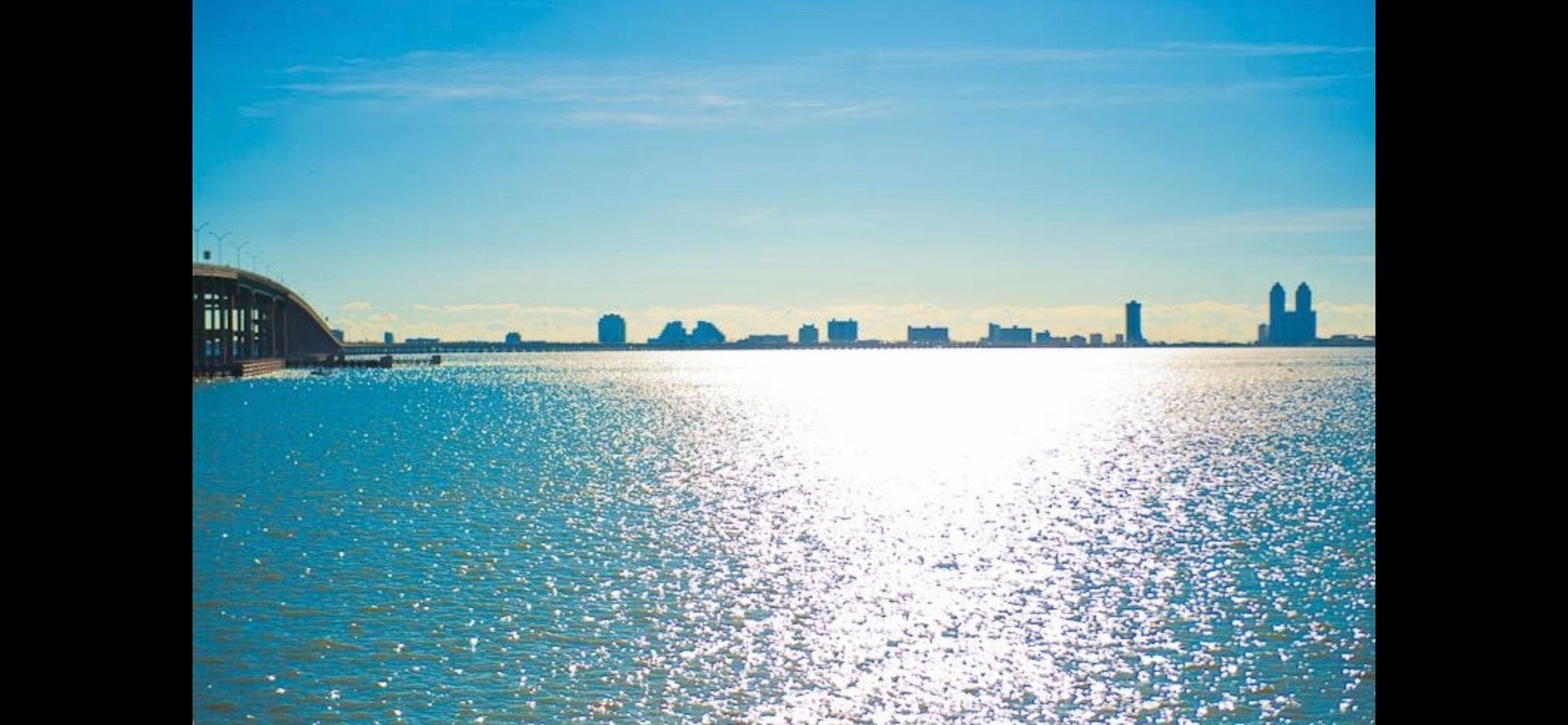 A city skyline is visible over a body of water.