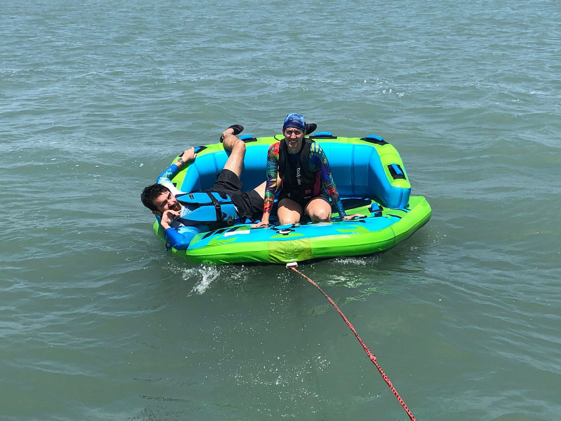 A man and a woman are riding a raft in the water.
