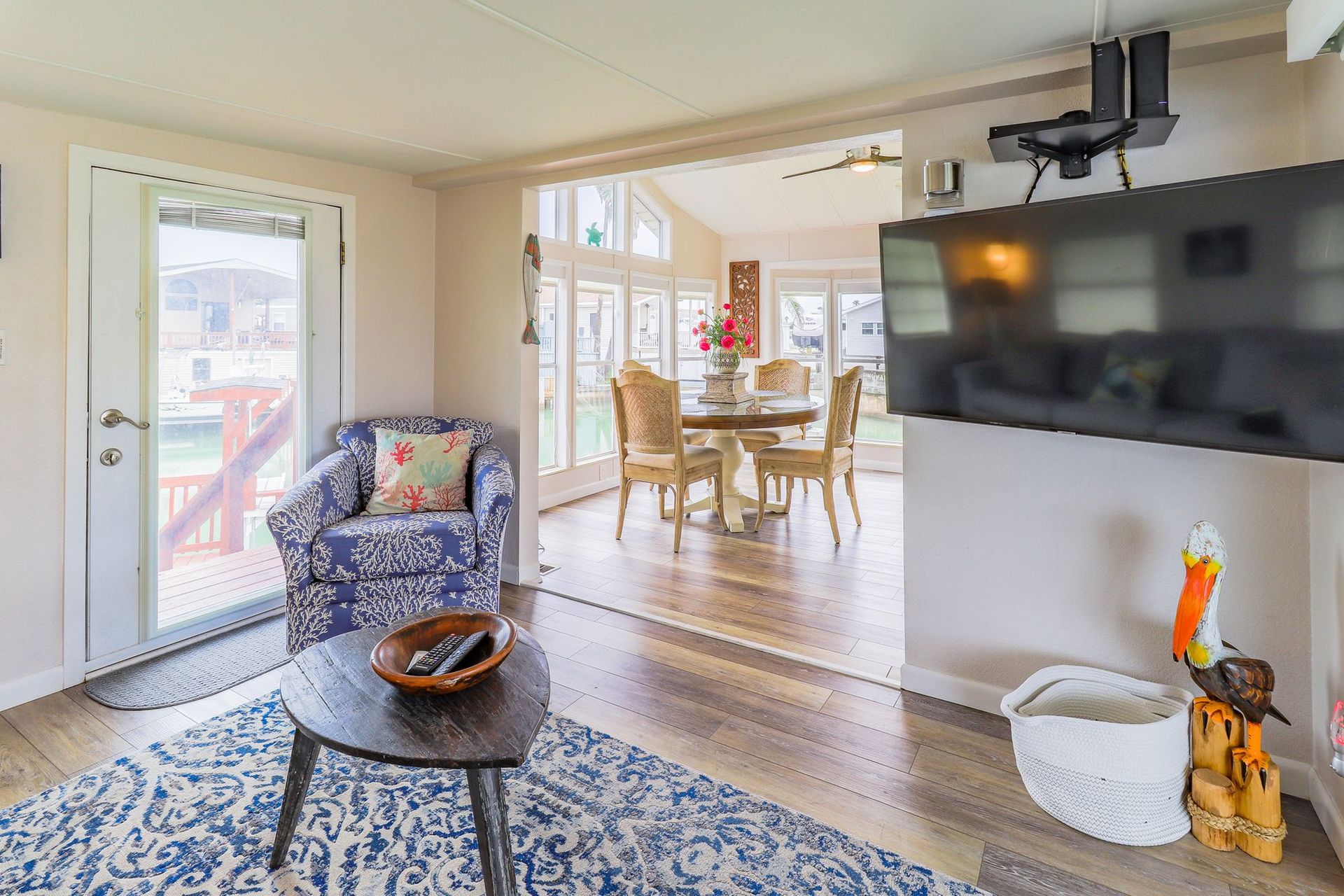 A living room with a table , chairs , and a flat screen tv.