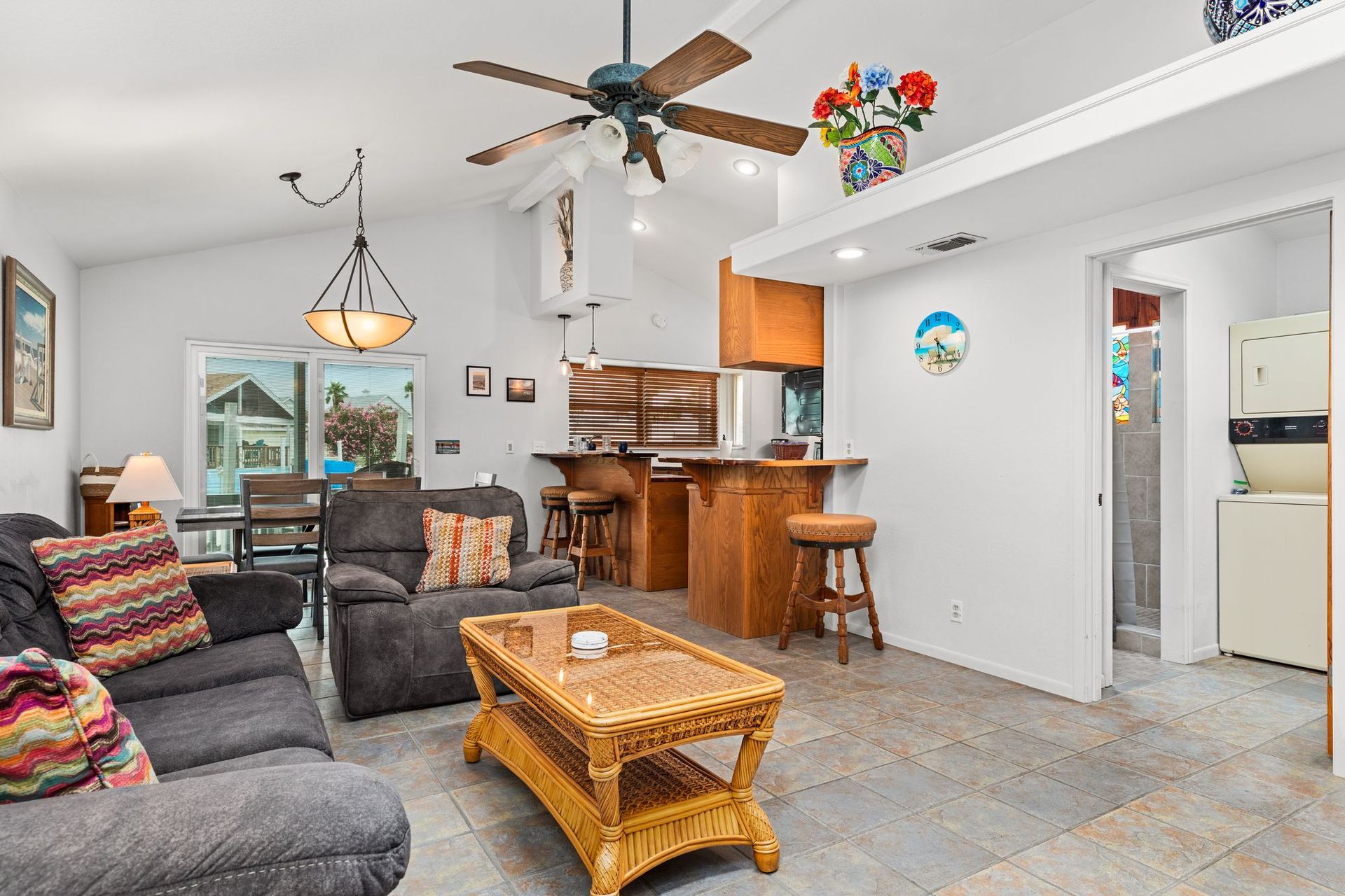 A living room with a couch , chairs , coffee table and ceiling fan.