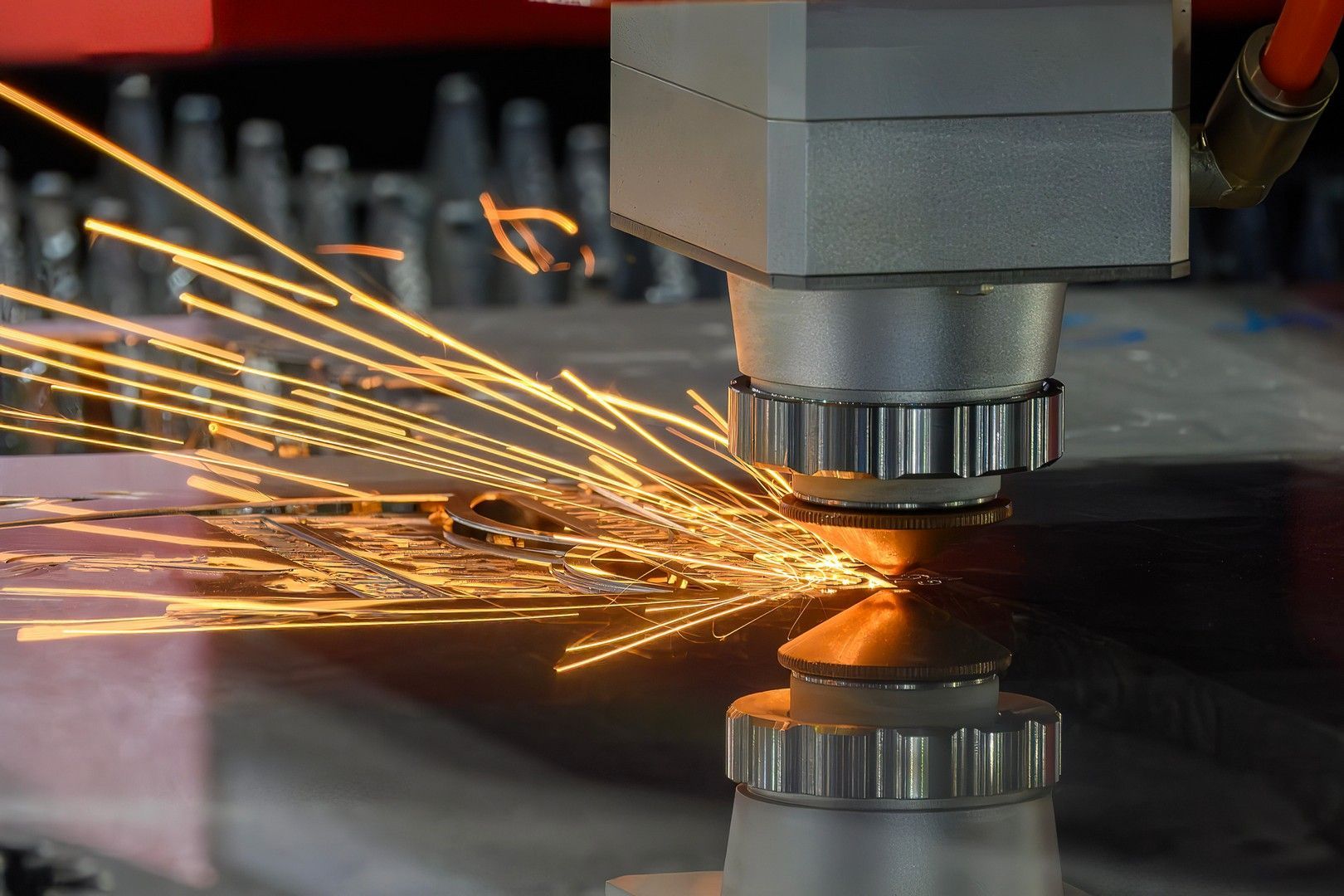 Il laser taglia il metallo, emettendo scintille e luce brillanti in un ambiente industriale.