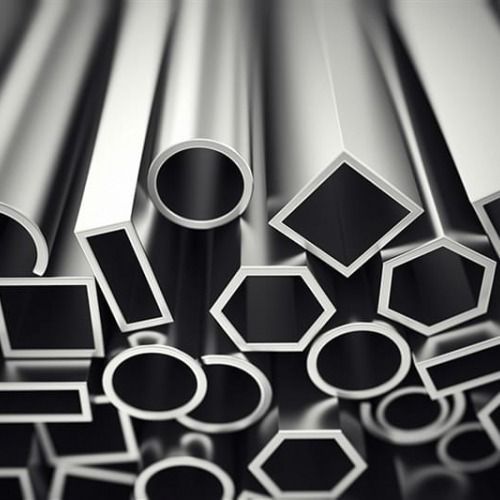 Assortimento di barre e tubi metallici di varie forme geometriche, che riflettono la luce su una superficie scura.