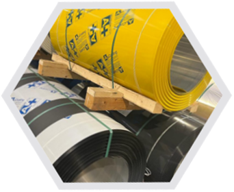 Rotoli di lamiera gialla e nera su un pallet di legno, pronti per l'uso.