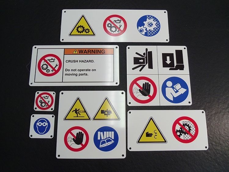 Raccolta di segnali di sicurezza industriale, bianchi con vari simboli di avvertimento in nero, rosso e blu.