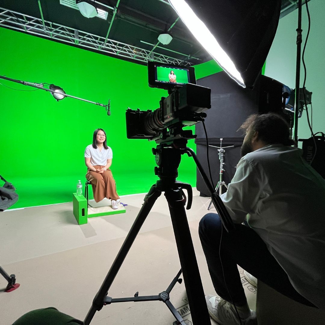 a woman filmed in front of green screen
