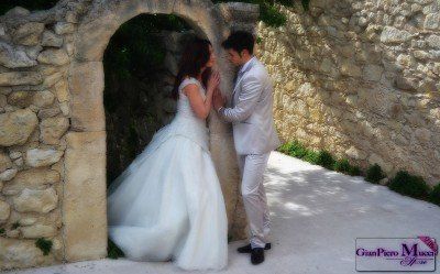 sposi in posa accanto un piccolo arco