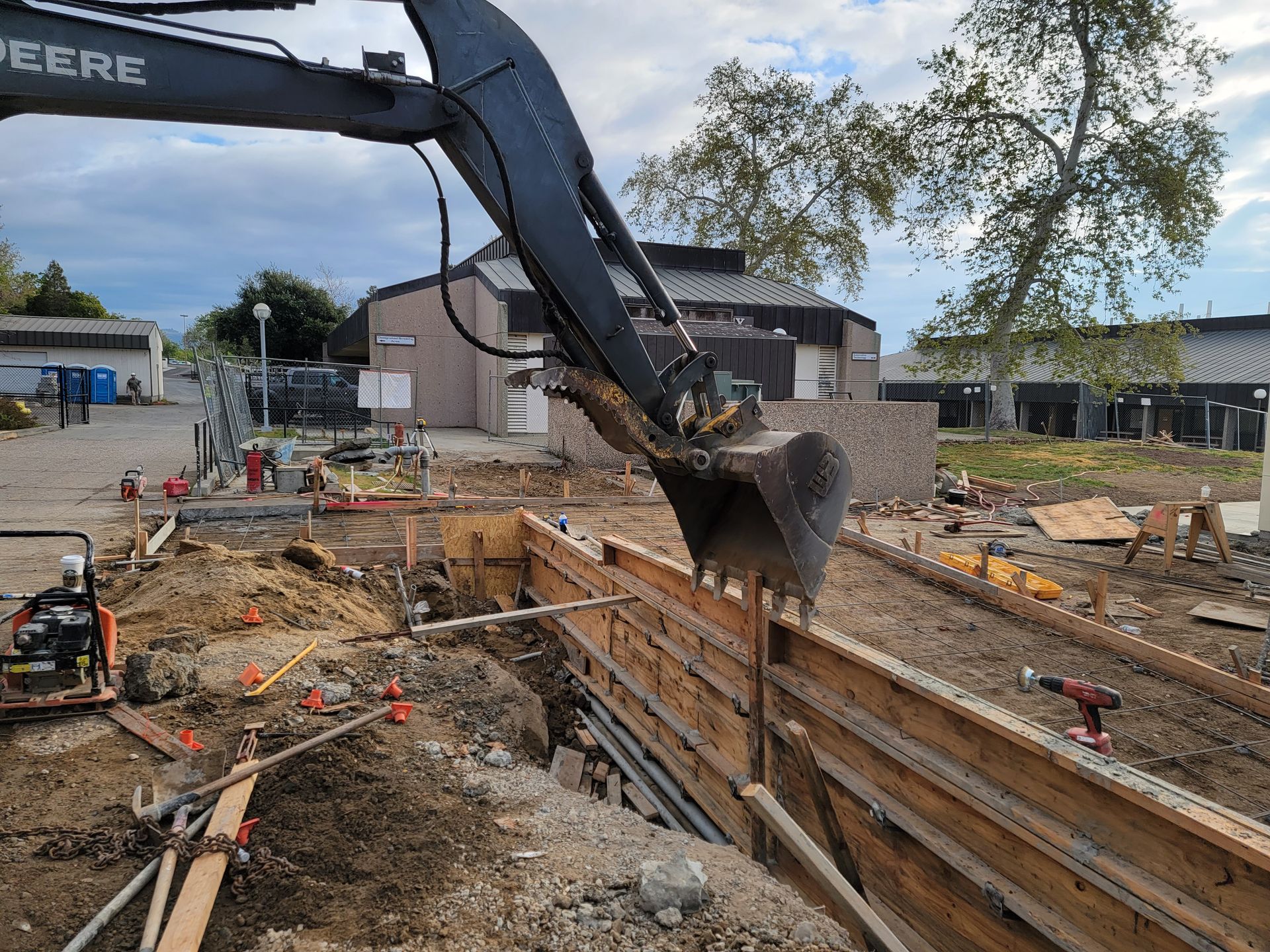 A john deere excavator is digging a hole in a construction site.